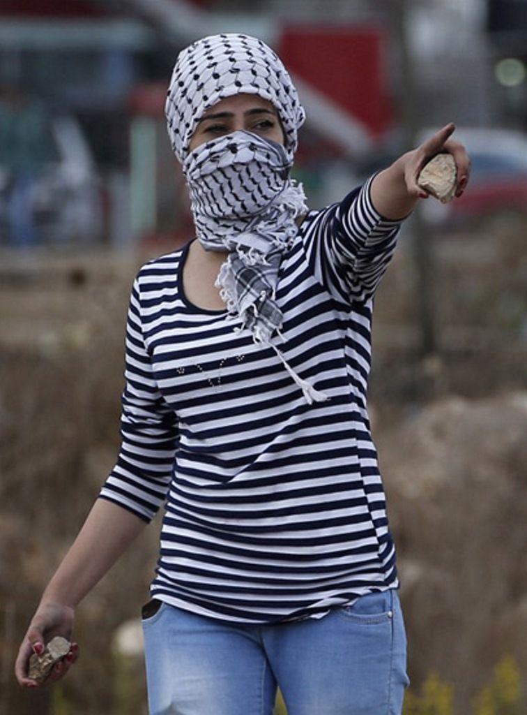 Perempuan Palestina dengan dua batu pada masing-masing tangannya//Foto: Abed Al Hashlamoun - EPA 