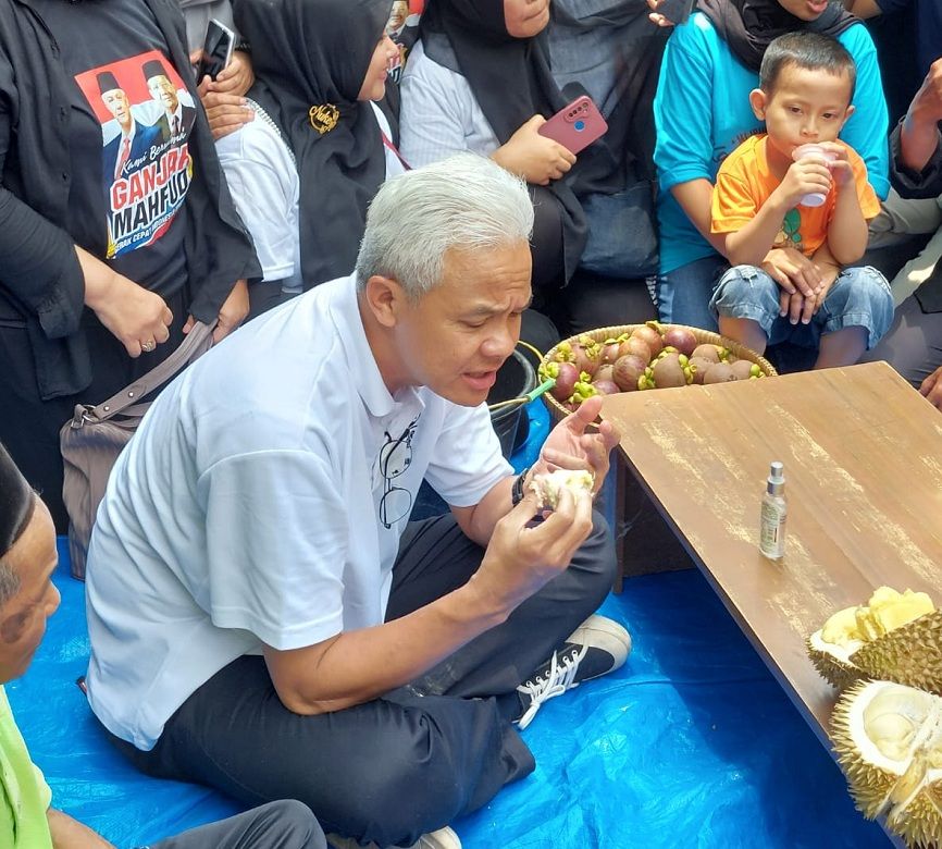 Ganjar Pranowo makan durian di kebun warga di Desa Wilayu, Kecamatan Selomerto di sela-sela kegiatan kampanye di Wonosobo, Senin 18 Desember 2023.