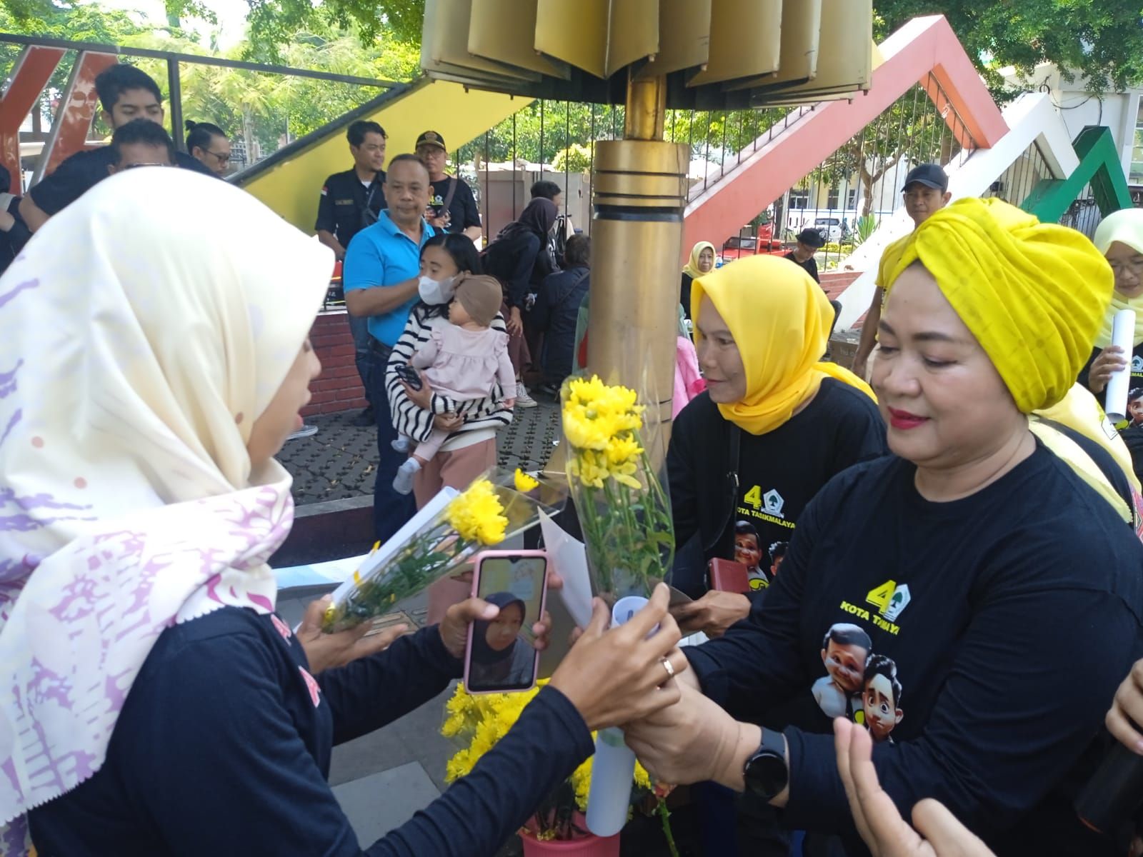 KETUA HWK Ina Fartini menyerahkan bunga kepada kaum ibu yang melintas ke taman Kota.*