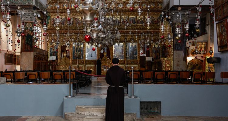 Seorang biarawan berdiri di dalam Gereja Kelahiran pada hari peluncuran awal musim Natal, ketika konflik antara Israel dan kelompok Islam Palestina Hamas berlanjut, di Betlehem di Tepi Barat yang diduduki Israel pada 2 Desember 2023.