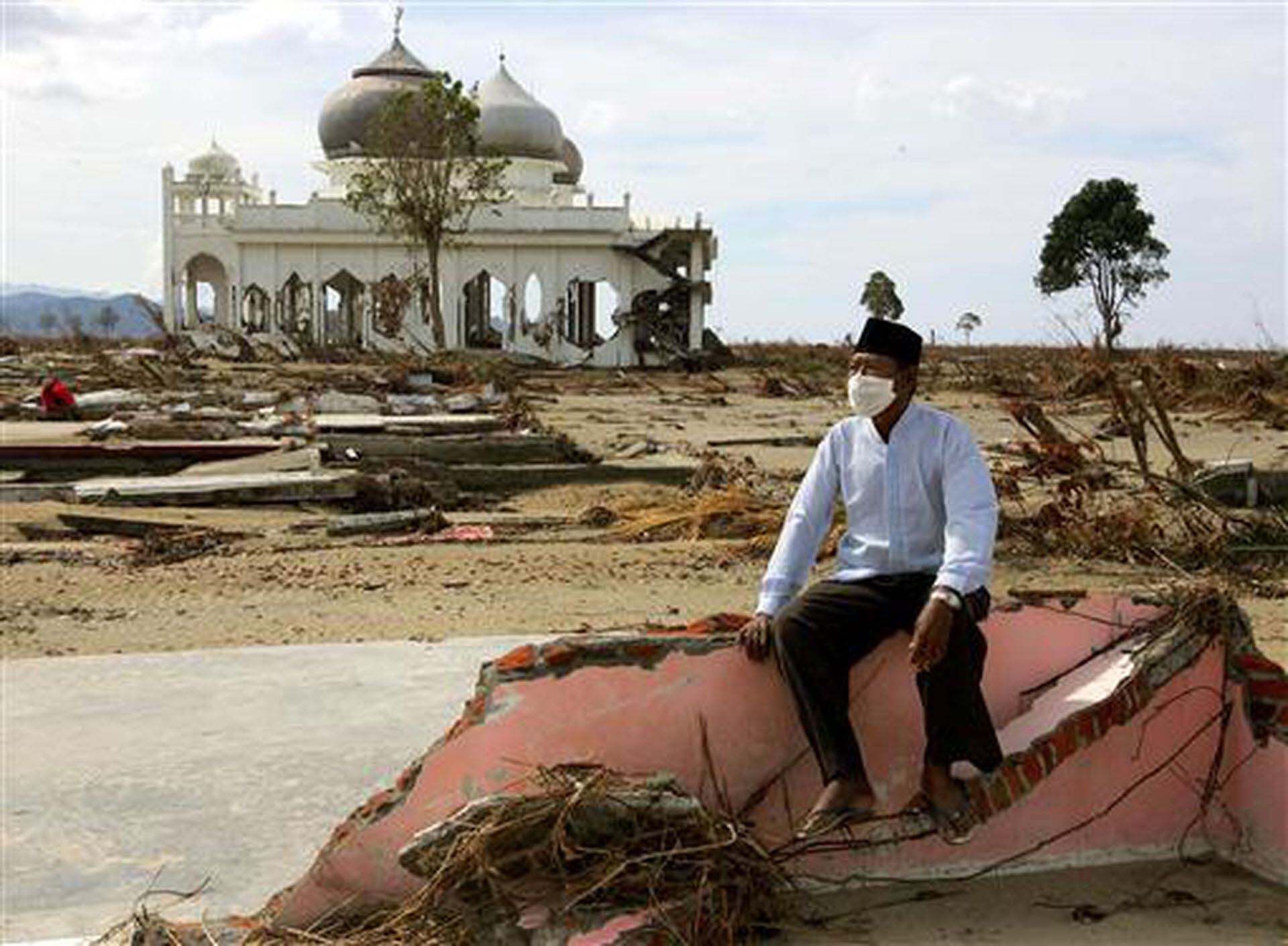 Seorang pria Aceh yang kehilangan keluarganya dalam bencana tsunami duduk di antara reruntuhan rumahnya di dekat Banda Aceh, di bagian utara pulau Sumatra, Indonesia, 2 Januari 2005.