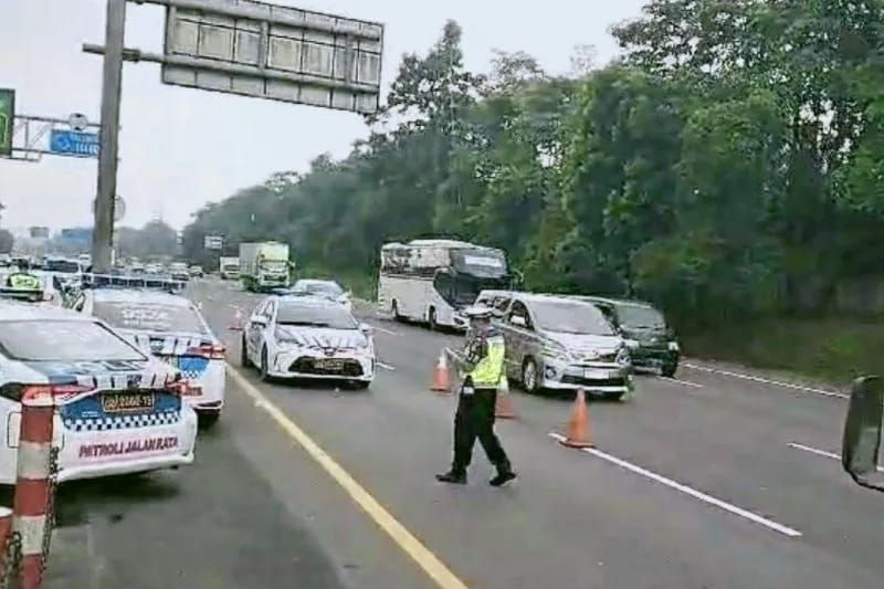 Petugas menghentikan contraflow di jalan Tol Jakarta-Cikampek. 