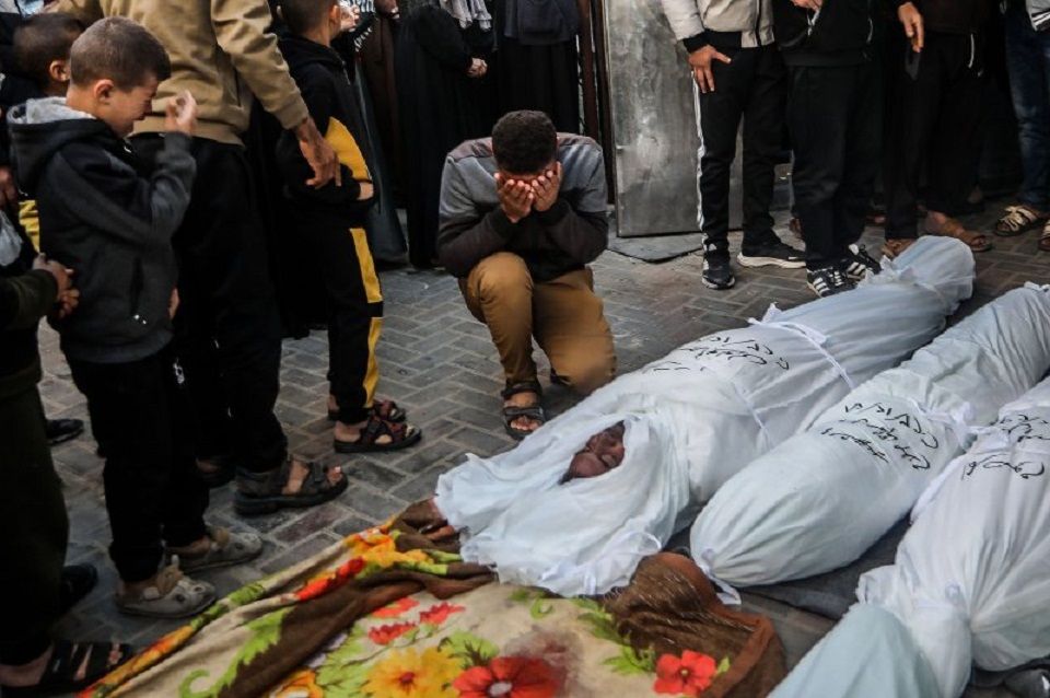 Seorang pria Palestina meratapi jenazah keluarganya yang terbunuh di Rafah dalam pemboman Israel di Gaza, Jumat. Afrika Selatan pada hari Jumat mengajukan kasus ke Mahkamah Internasional PBB yang menuduh Israel melakukan genosida di Gaza.* 