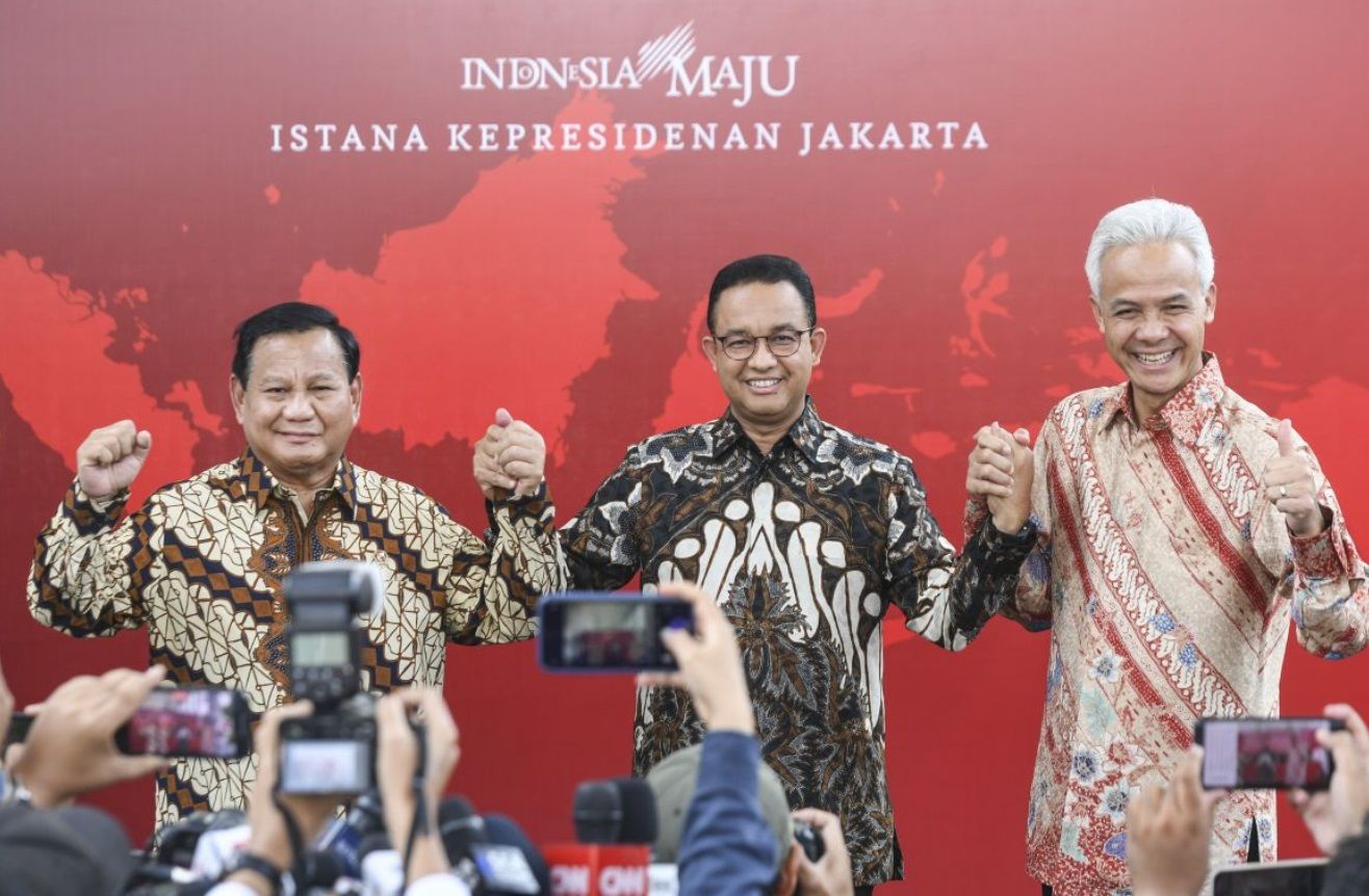 Capres Anies Baswedan (tengah), Ganjar Pranowo (kanan) dan Prabowo Subianto (kiri) bergandengan tangan usai melakukan pertemuan dengan Presiden Joko Widodo di Kompleks Istana Kepresidenan, Jakarta pada Senin, 30 Oktober 2023.