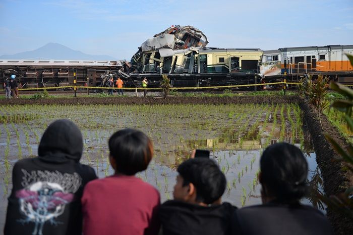 Sejumlah warga melihat kereta api lokal Bandung Raya yang bertabrakan dengan kereta api Turangga di Cicalengka, Kabupaten Bandung, Jawa Barat, Jumat, 5 Januari 2024.