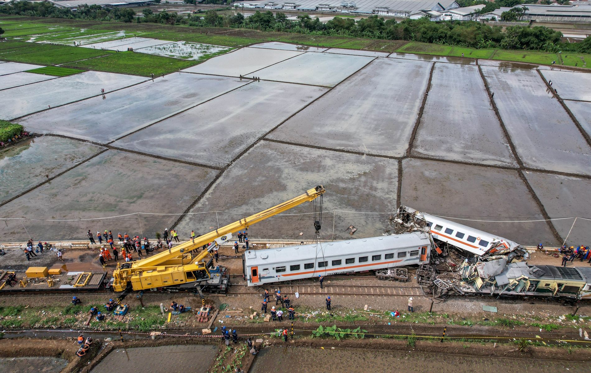 Foto udara petugas yang mengoperasikan alat berat untuk mengevakuasi rangkaian kereta yang mengalami kecelakaan di Cicalengka, Kabupaten Bandung, Jawa Barat, Jumat (5/1/2024).