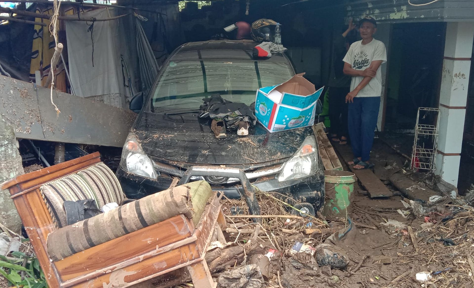 Banjir yang terjadi di Dayeuhkolot, Kabupaten Bandung menyebabkan mobil milik warga tertimbun tanah dan sampah, Sabtu 13 Januari 2024