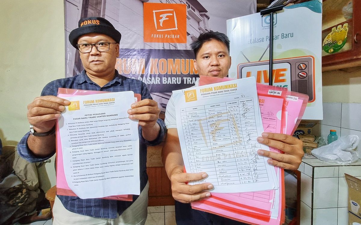 Ketua Fokus Pasbar Kurnia (kiri) dan Sekretaris Fokus Pasbar Dany Mauladi menunjukkan surat petisi beserta lembar tanda tangan pedagang di Pasar Baru Trade Center, Jalan Otista, Kota Bandung, Senin, 15 Januari 2024.