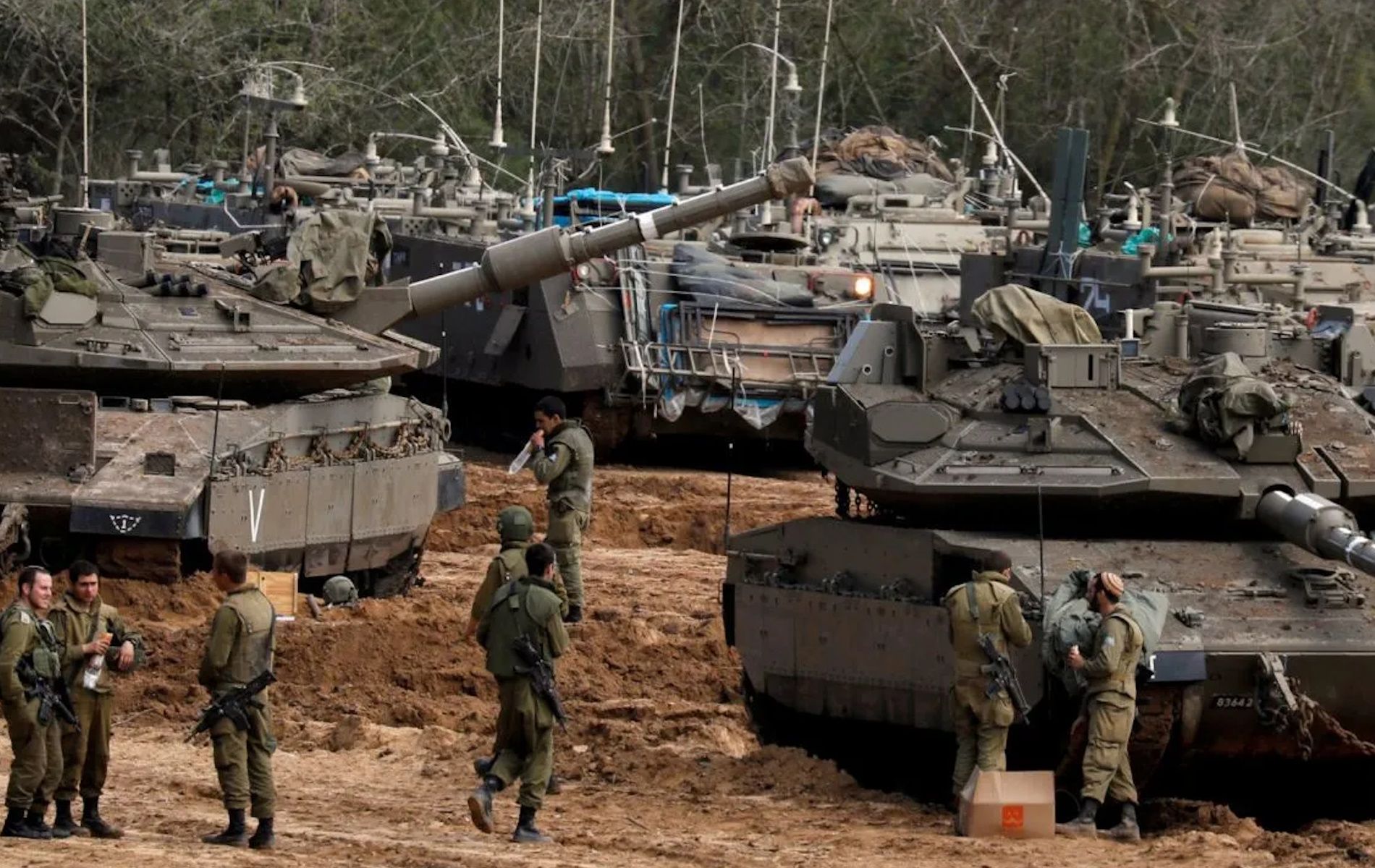 Tentara Israel berjaga di sebelah tank dan kendaraan lapis baja (APC) dekat perbatasan dengan Gaza, di selatan Israel, Selasa (26/3/2019).