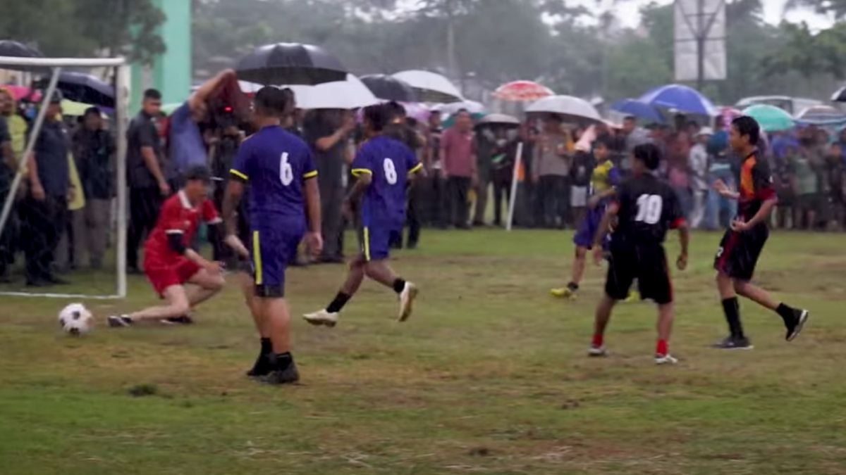 Presiden Jokowi (seragam merah) bertanding sepak bola dengan remaja di Sleman.