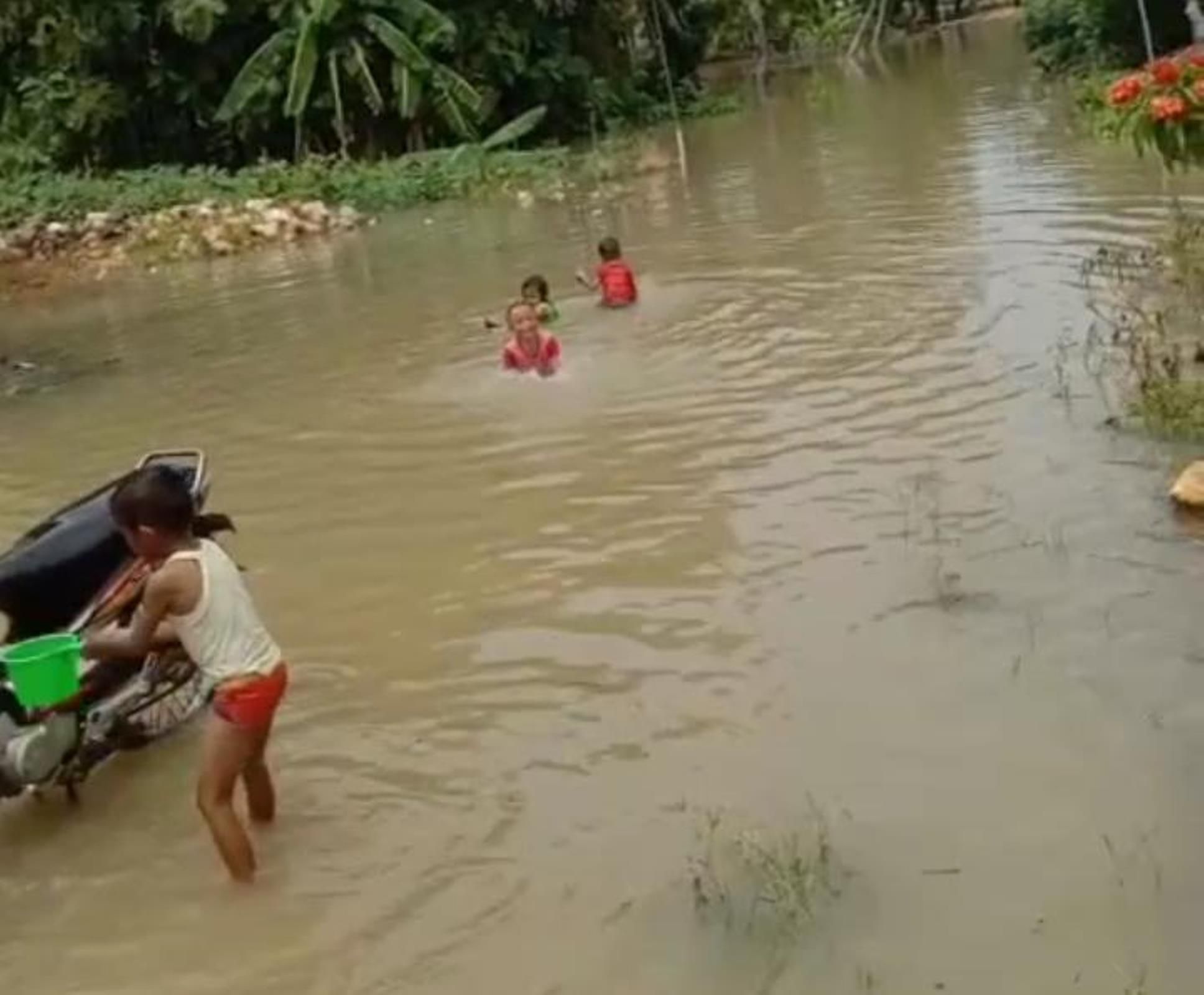 Anak-anak bermain air di tengah banjir yang terjadi di Desa Toko, Kecamatan Penawangan.