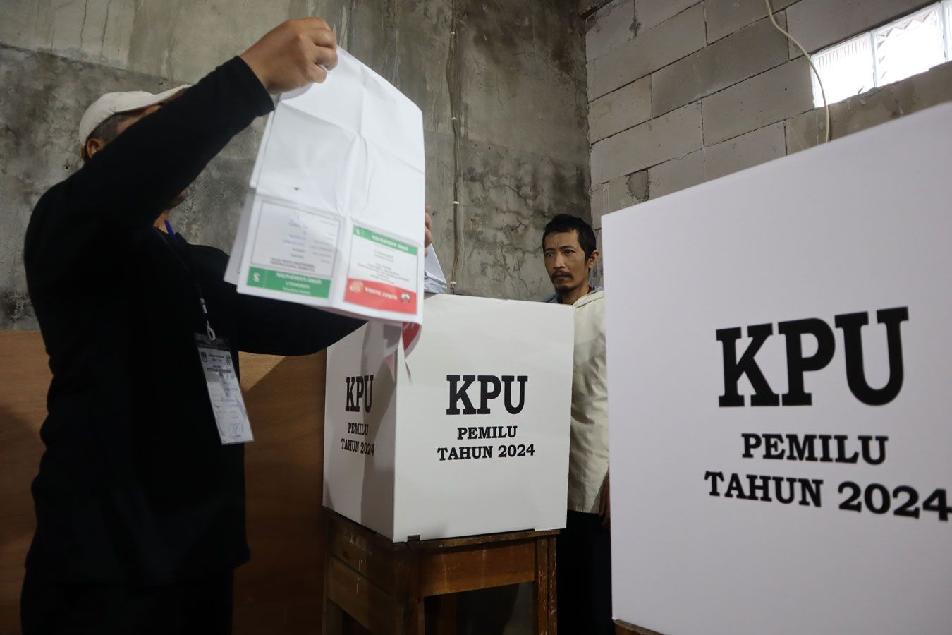 Petugas Kelompok Penyelenggara Pemungutan Suara (KPPS) dari Tempat Pemungutan Suara (TPS) 18 di Dusun Citeureup, RW 10 Desa Cilayung, Kecamatan Jatinangor, Kabupaten Sumedang sedang membantu Orang Dalam Gangguan Jiwa (ODGJ) memberikan hak suaranya dalam Pemilu 2024 pada 14 Februari 2024.