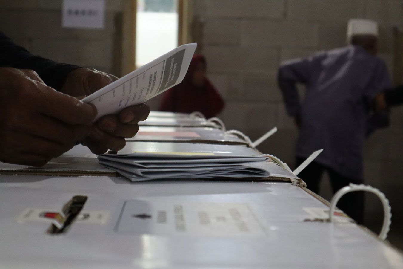 Petugas Kelompok Penyelenggara Pemungutan Suara (KPPS) dari Tempat Pemungutan Suara (TPS) 18 di Dusun Citeureup, RW 10 Desa Cilayung, Kecamatan Jatinangor, Kabupaten Sumedang sedang memasukkan suarat suara Pemilu 2024 ke kotak suara pada hari pencoblosan 14 Februari 2024.
