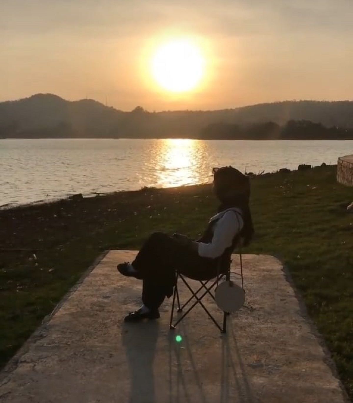 Seorang pengunjung sedang menikmati suasana matahari terbenam di Waduk Darma Kuningan.*/Instagram /@kuningan_eksiss