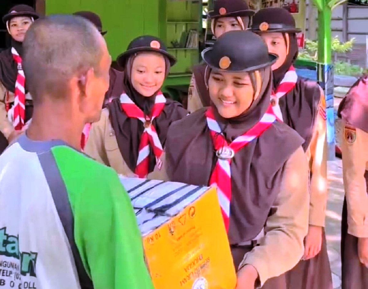 Anggota Pramuka peserta Perkemahan Penggalang Ceria membagikan sembako ke warga tak jauh dari SMPN 1 Grobogan.