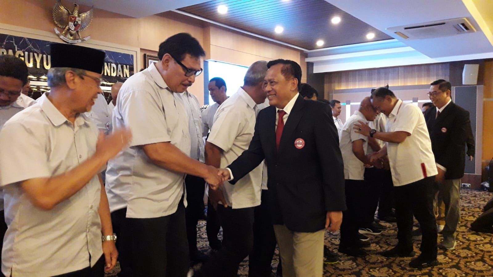 Ketua Umum PP PBVSI Imam Sudjarwo (berjas) bersalaman dengan Ketua Harian Pengprov PBVSI Jawa Barat Gugi Gustaman saat pelantikan di Aula Paguyuban Pasundan, Senin 19 Februari 2024. 
