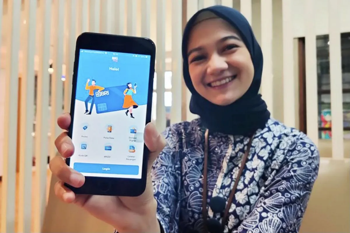 Salah seorang petugas Bank Rakyat Indonesia (BRI) menunjukkan menunjukkan aplikasi BRImo, yang dinilai mampu memberikan kemudahan transaksi perbankan untuk nasabah. 