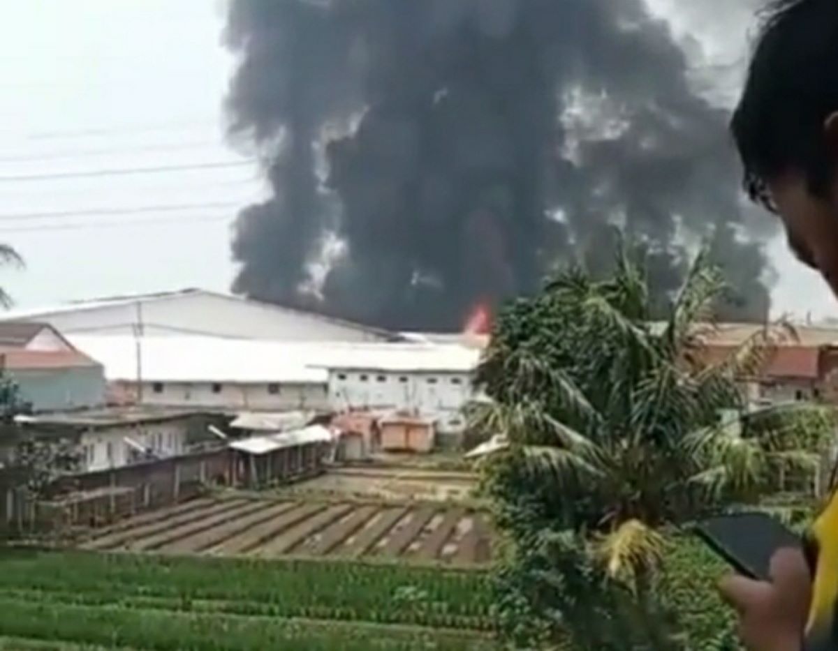 Kepulan asap hitam membungbung ke udara di tiup angin akibat kebakaran di salah satu bangunan kawasan pabrik tekstil Kahatex