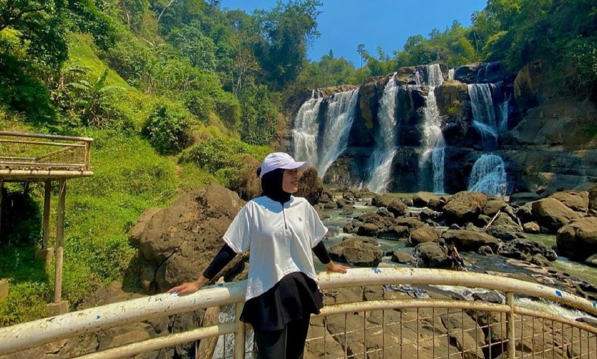 Seorang wisatawan tengah berfoto dengan latar belakang Curug Malela yang merupakan wisata alam favorit di Bandung Barat.*
