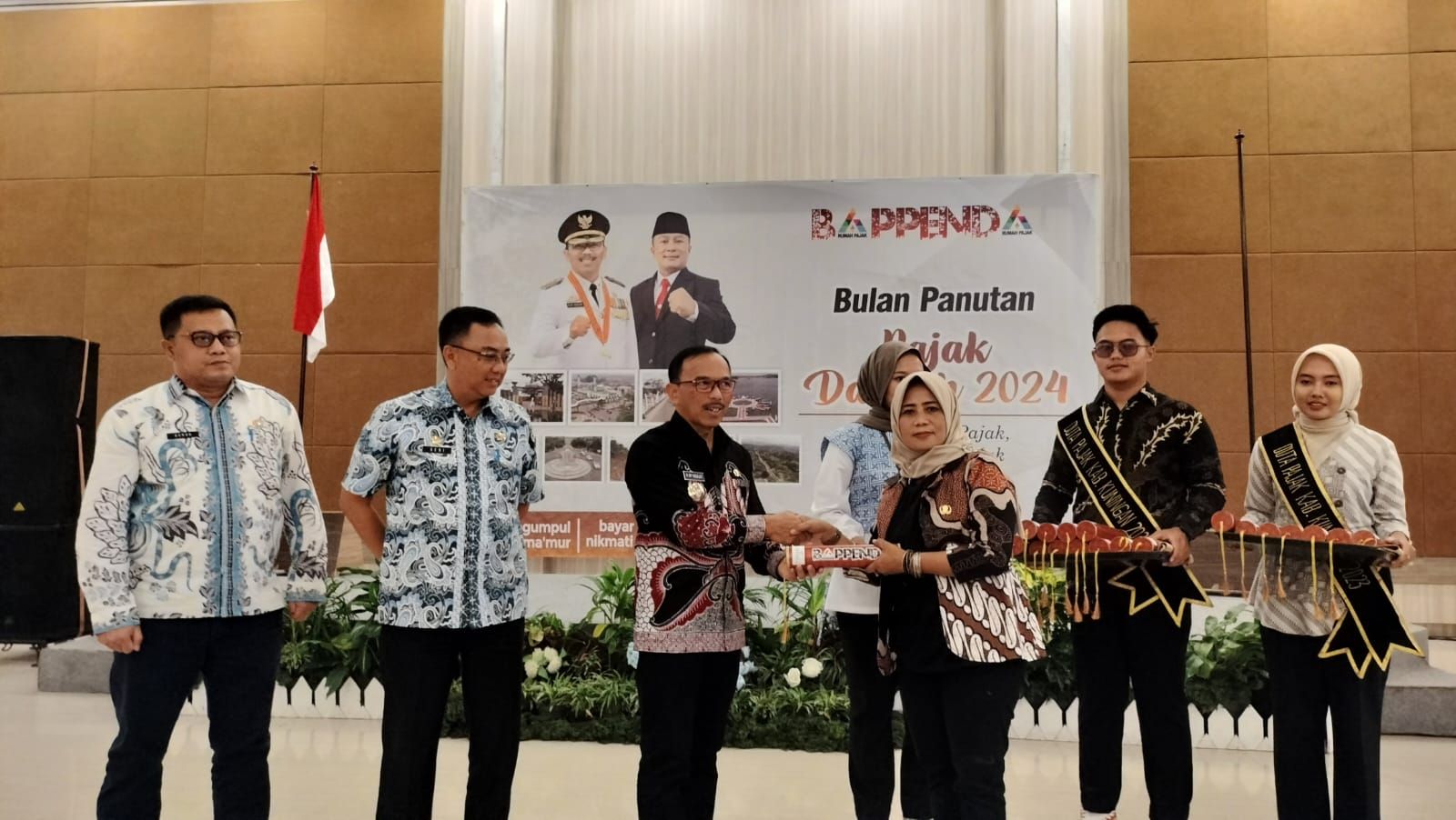 Pj Bupati Kuningan, H. Raden Iip Hidajat memberikan penghargaan kepada kades yang tercepat dalam pelunasan PBB-P2 di sela-sela kegiatan Bulan Panutan Pajak Daerah di Hotel Horison Tirta Sanita.