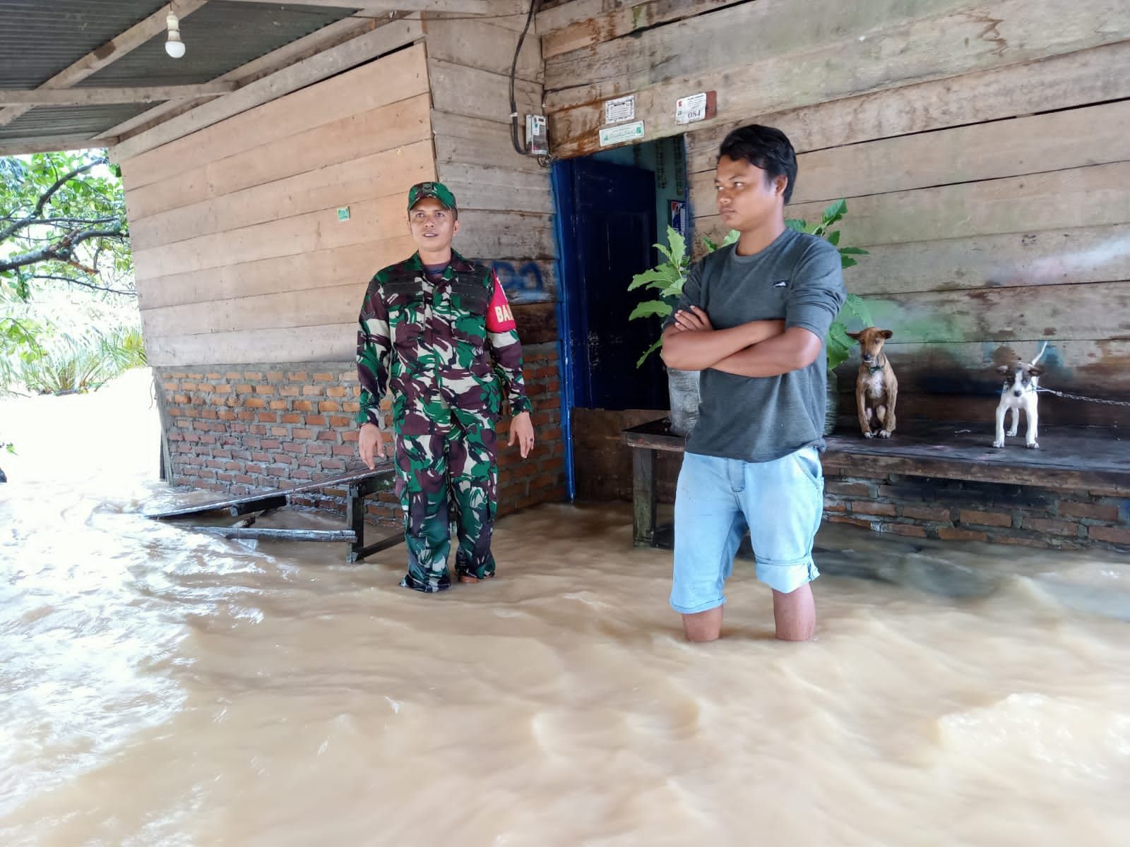 Babinsa bersama seorang warga ditengah banjir