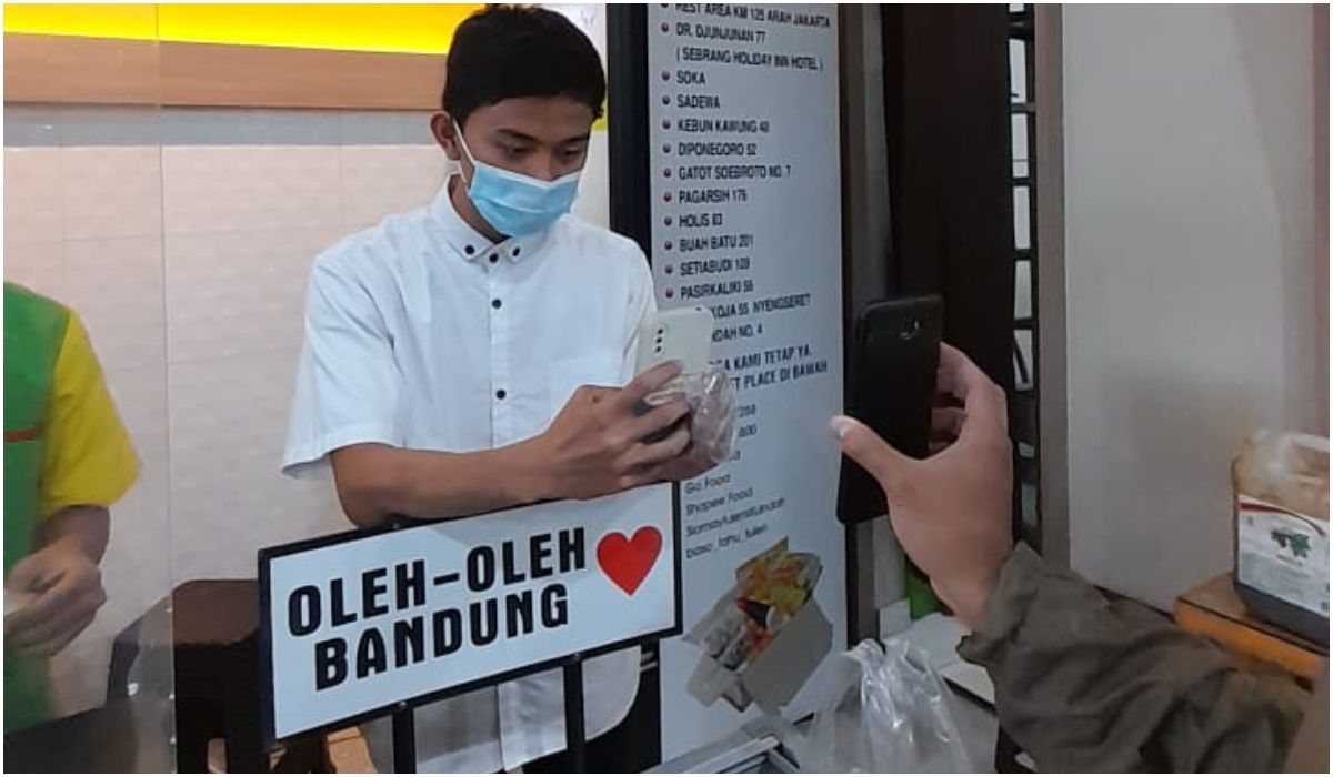 Ilustrasi pembayaran dengan metode QRIS. Kasir restoran Baso Tahu Tulen Situ Indah sedang memotret bukti pembayaran dengan fitur QRIS BRImo.