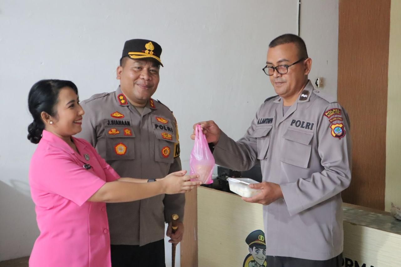Ketua Bhayangkari Ny Yulia Juleigtin Siahaan saat memberikan makanan takjil kepada personil Polsek Bolangitang