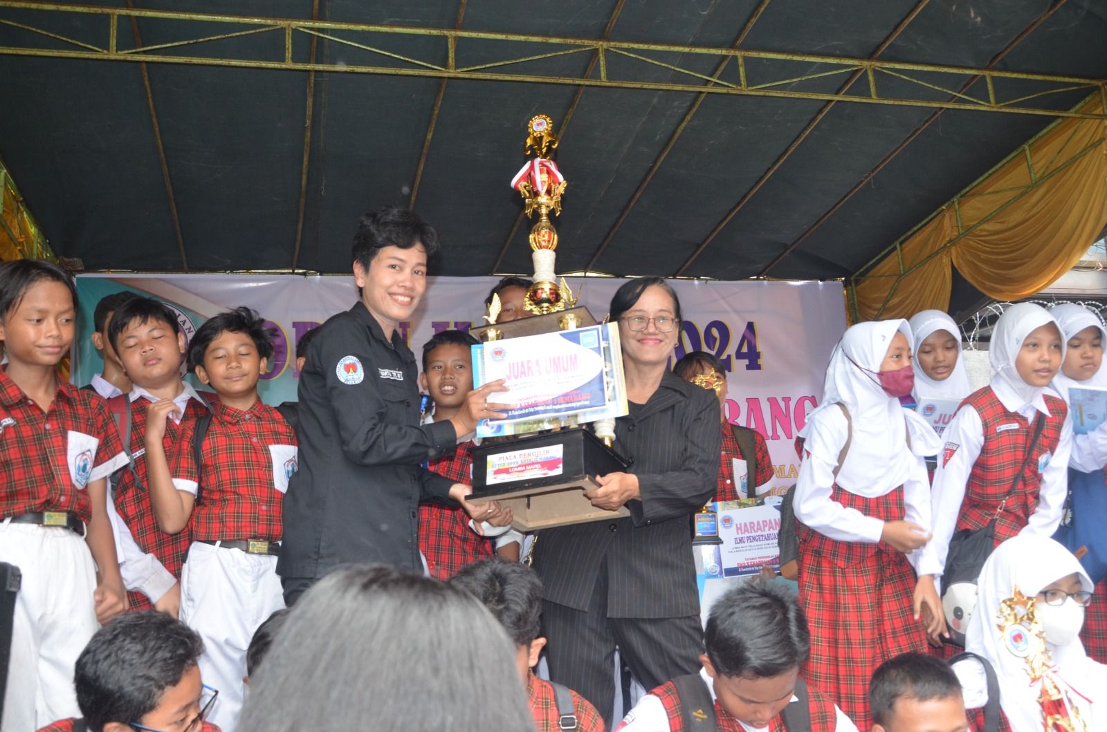 Kepala SMP Kesatrian 2 Semarang, Any Martha Triwulandari menyerahkan piala juara umum kepada sekolah yang meraih nilai tertinggi dalam lomba mata pelajaran tingkat SD/MI.