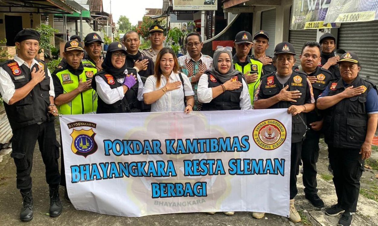 Petugas Polresta Sleman membagikan takjil berbuka puasa kepada warga yang melintas di Jalan Agrowisata Dusun Panasan Triharjo Sleman.