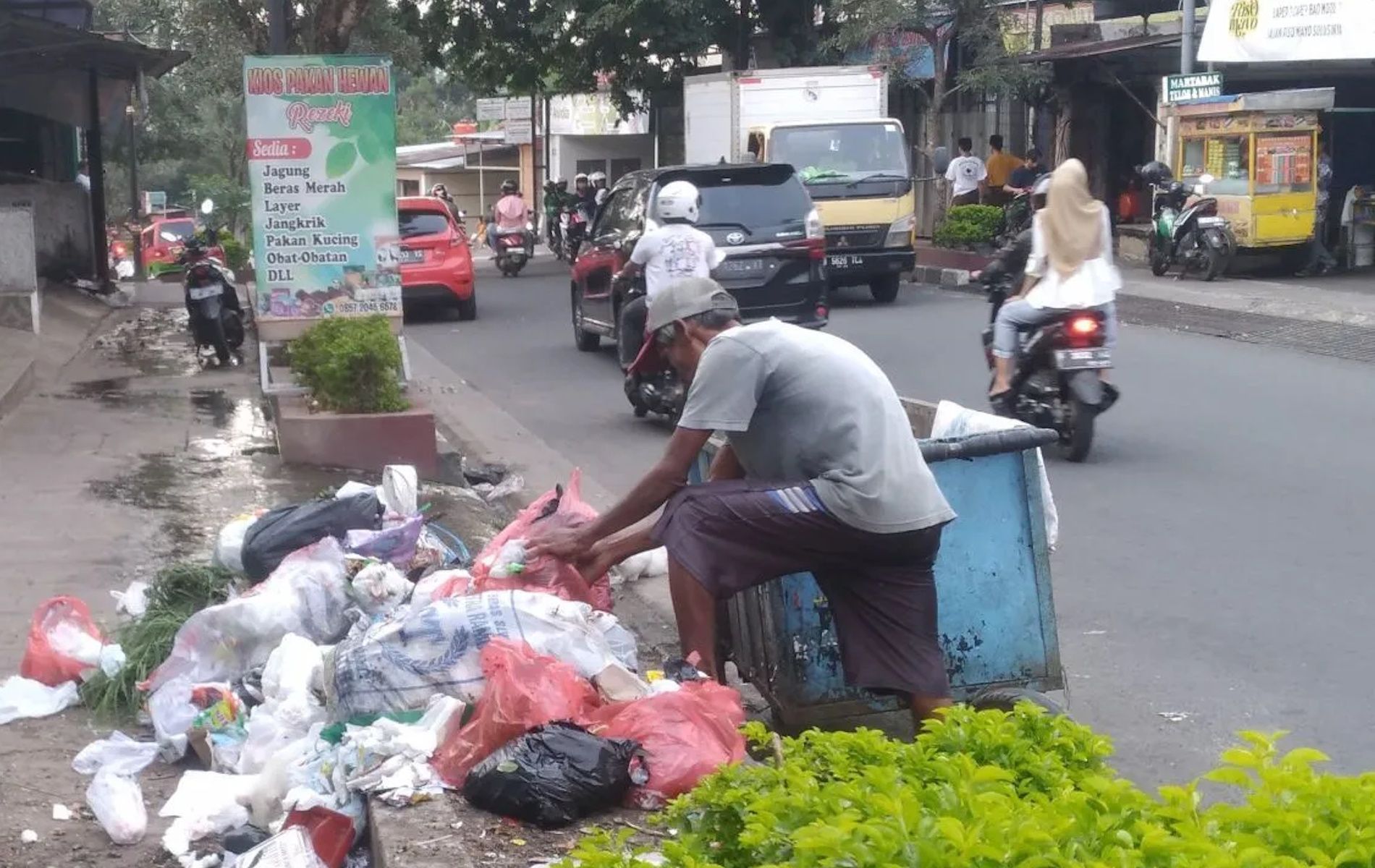Warga sedang membuang sampah sembarangan di pinggir jalan perkotaan wilayah Cianjur.