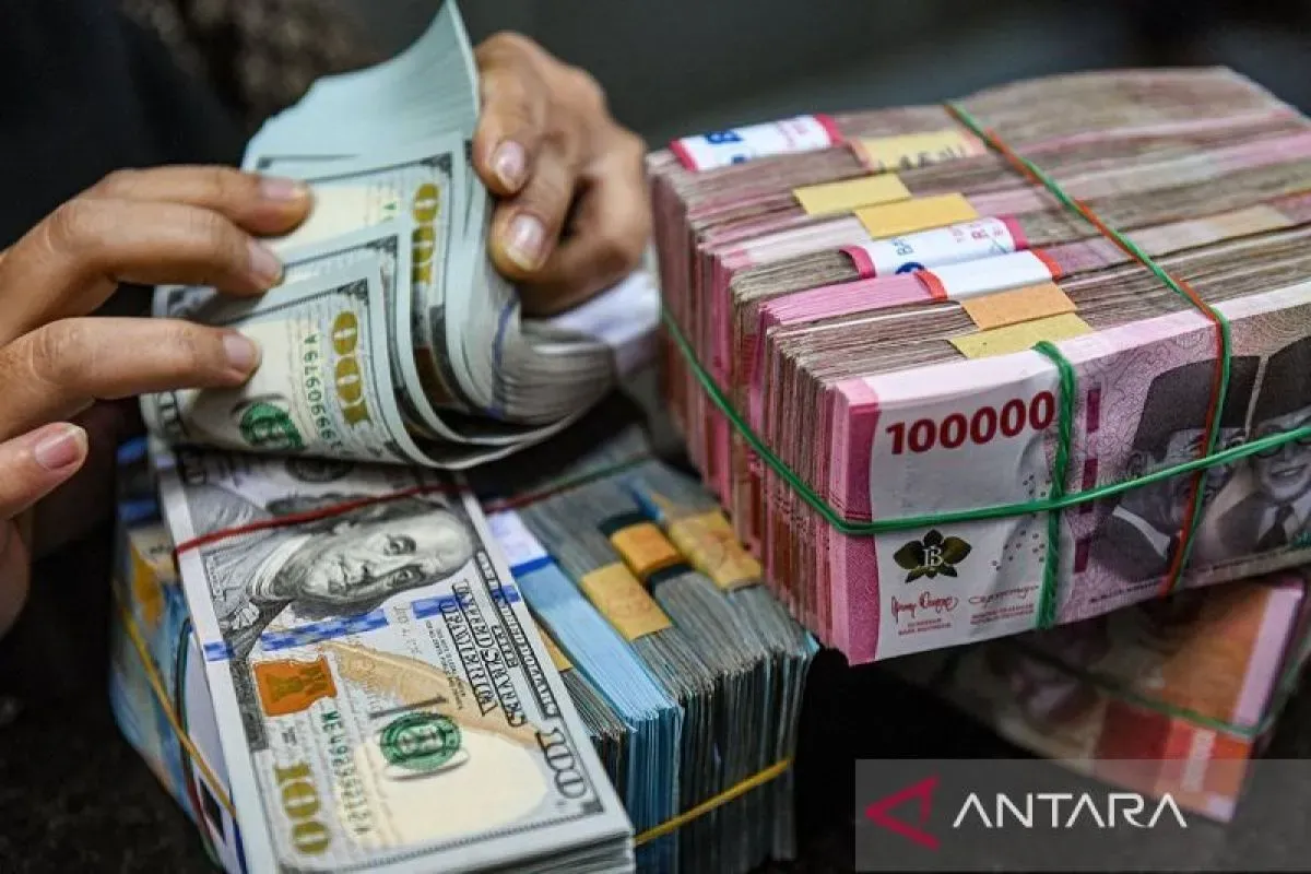 Ilustrasi - Petugas menghitung uang pecahan dolar AS dan rupiah di gerai penukaran mata uang asing 
