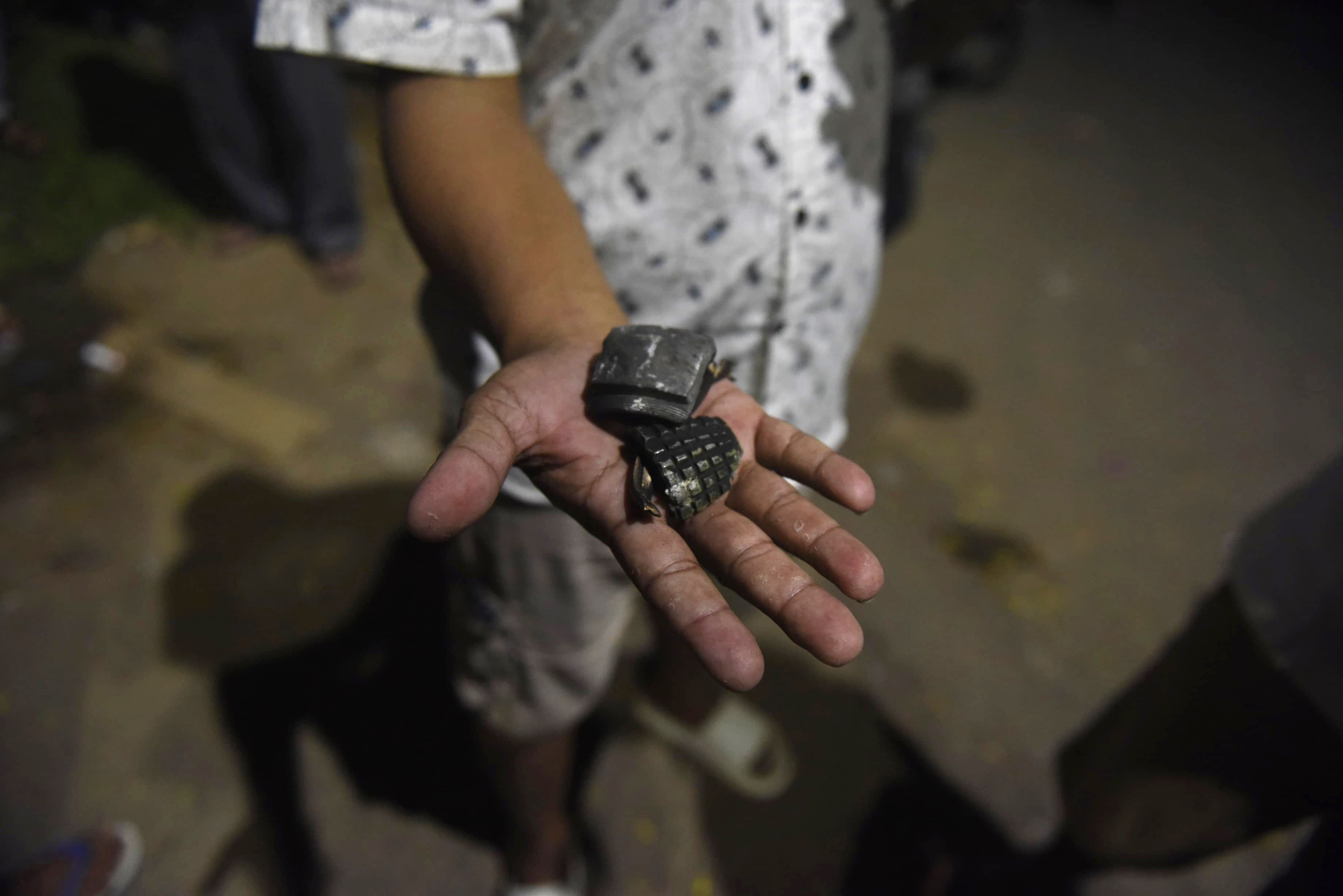 Seorang warga menunjukkan granat yang terlempar pascakebakaran gudang amunisi Yon Armed 7/105 GS Bantar Gebang di Cluster Kota Wisata Cibubur, Kabupaten Bogor, Jawa Barat, Sabtu (30/3/2024). Penyebab kebakaran gudang aminisi tersebut masih dalam penyelidikan pihak berwenang. 