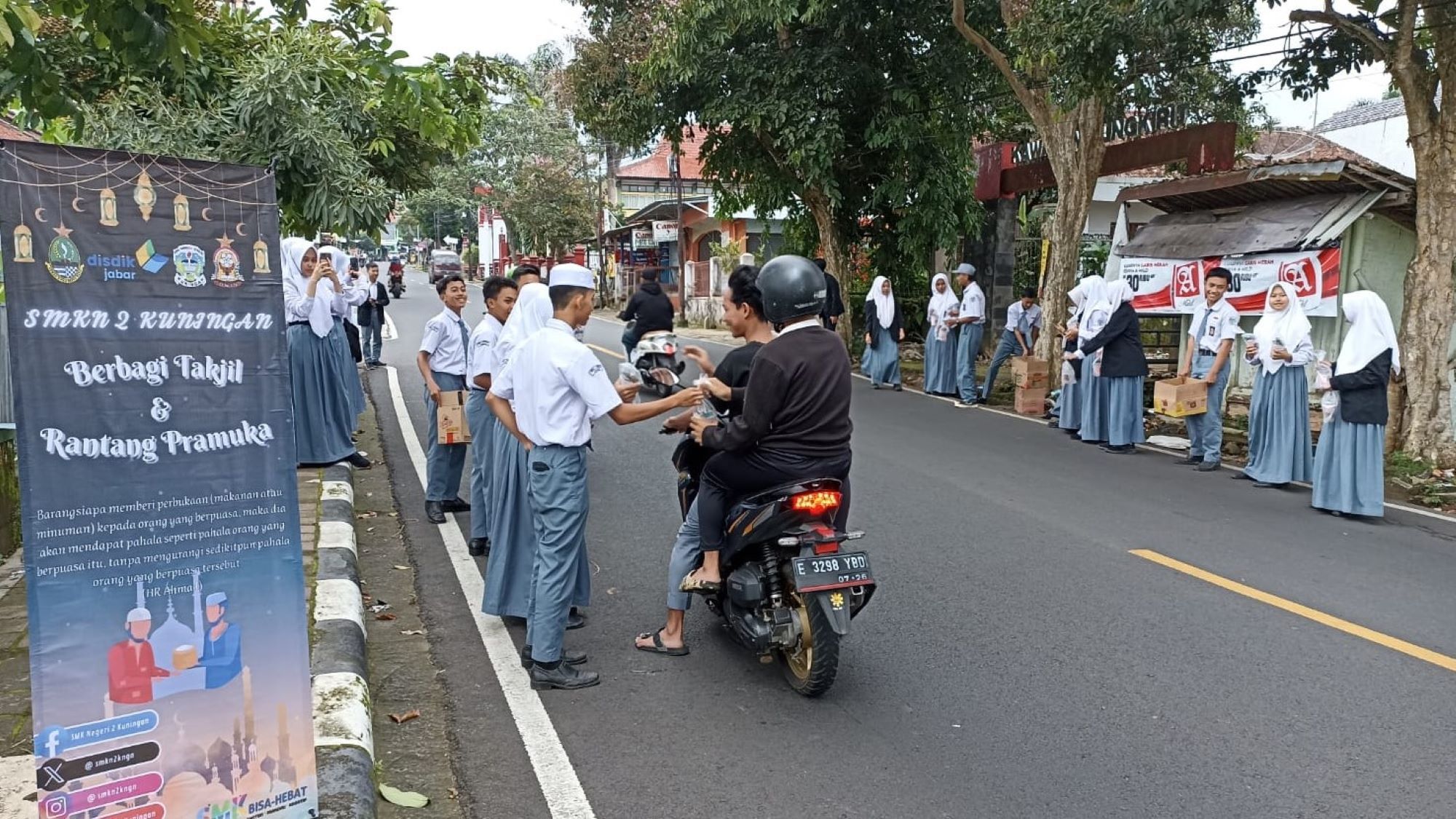 Siswa SMKN 2 Kuningan berbagi takjil dengan warga yang lalu lalang di Jalan Sukamulya Kecamatan Cigugur.