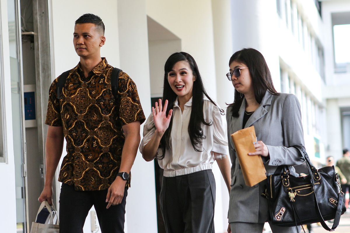 Artis Sandra Dewi (tengah) melambaikan tangan setibanya di Gedung Kejaksaan Agung RI, Jakarta, Kamis (4/4/2024).