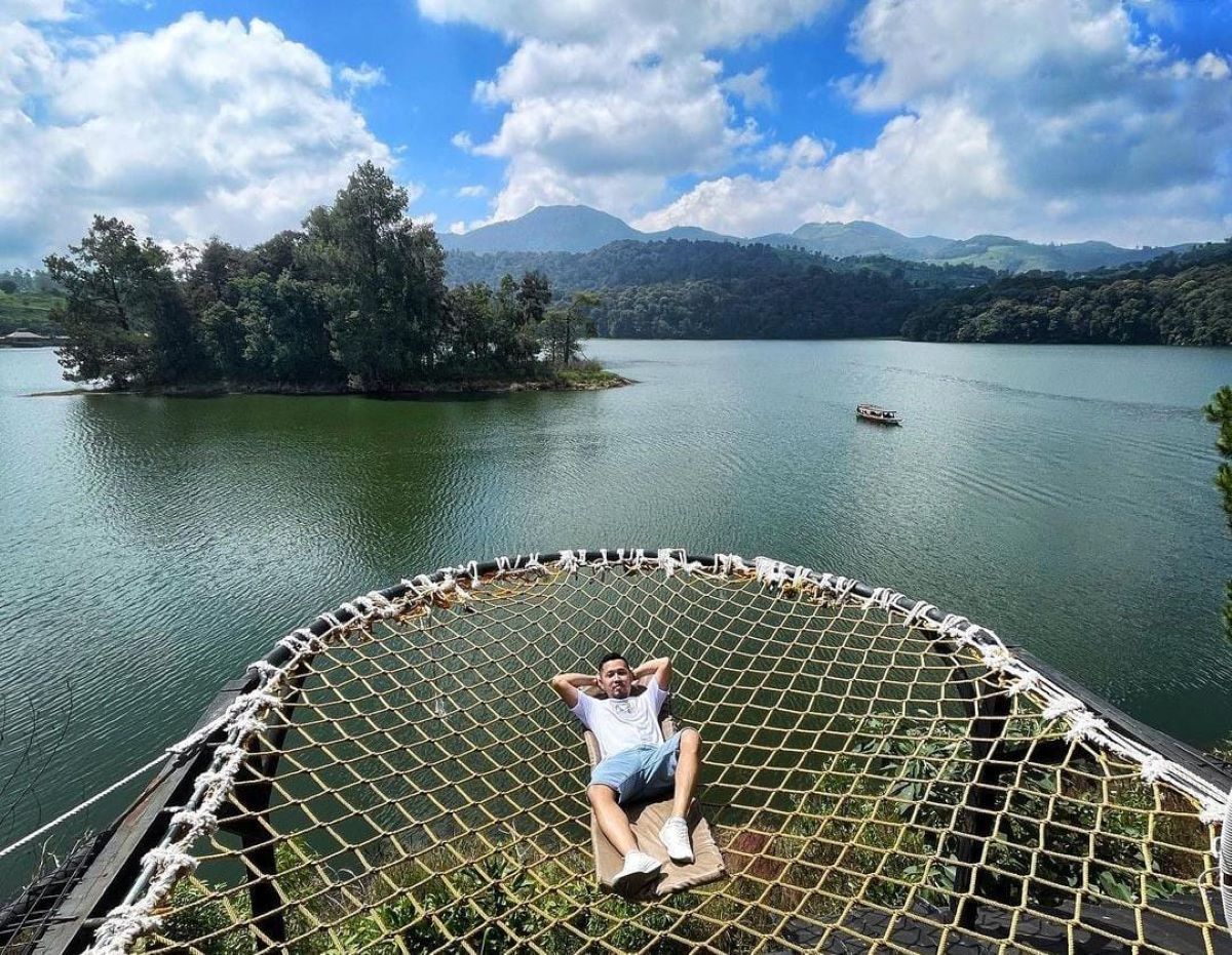 Terlihat seorang pengunjung sedang bersantai di tepi danau Situ Patenggang.