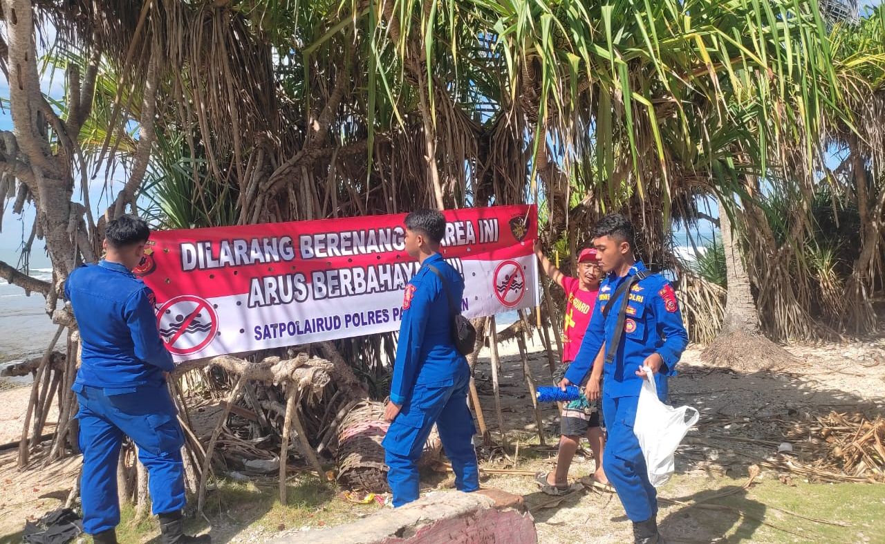 Anggota Satpolair Polres Pangandaran sedang memasang spanduk imbauan dan rambu - rambu larangan di sejumlah titik di kawasan pantai, Minggu 7 April 2024.