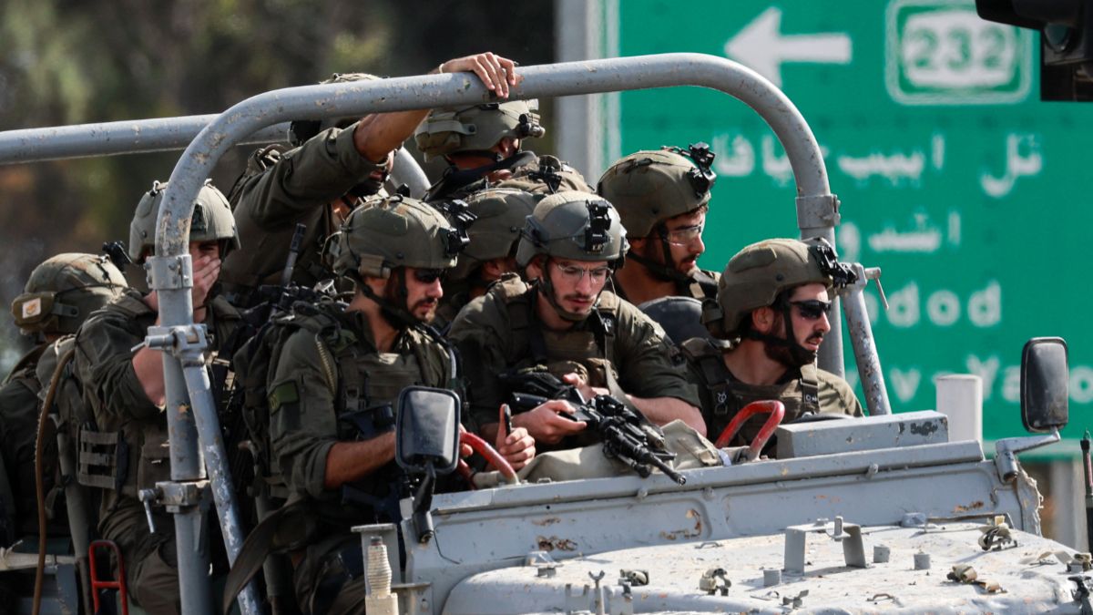 Militer Israel melaju di sebuah jalan di bagian selatan Israel, sementara roket-roket diluncurkan dari Jalur Gaza, pada 7 Oktober 2023. 
