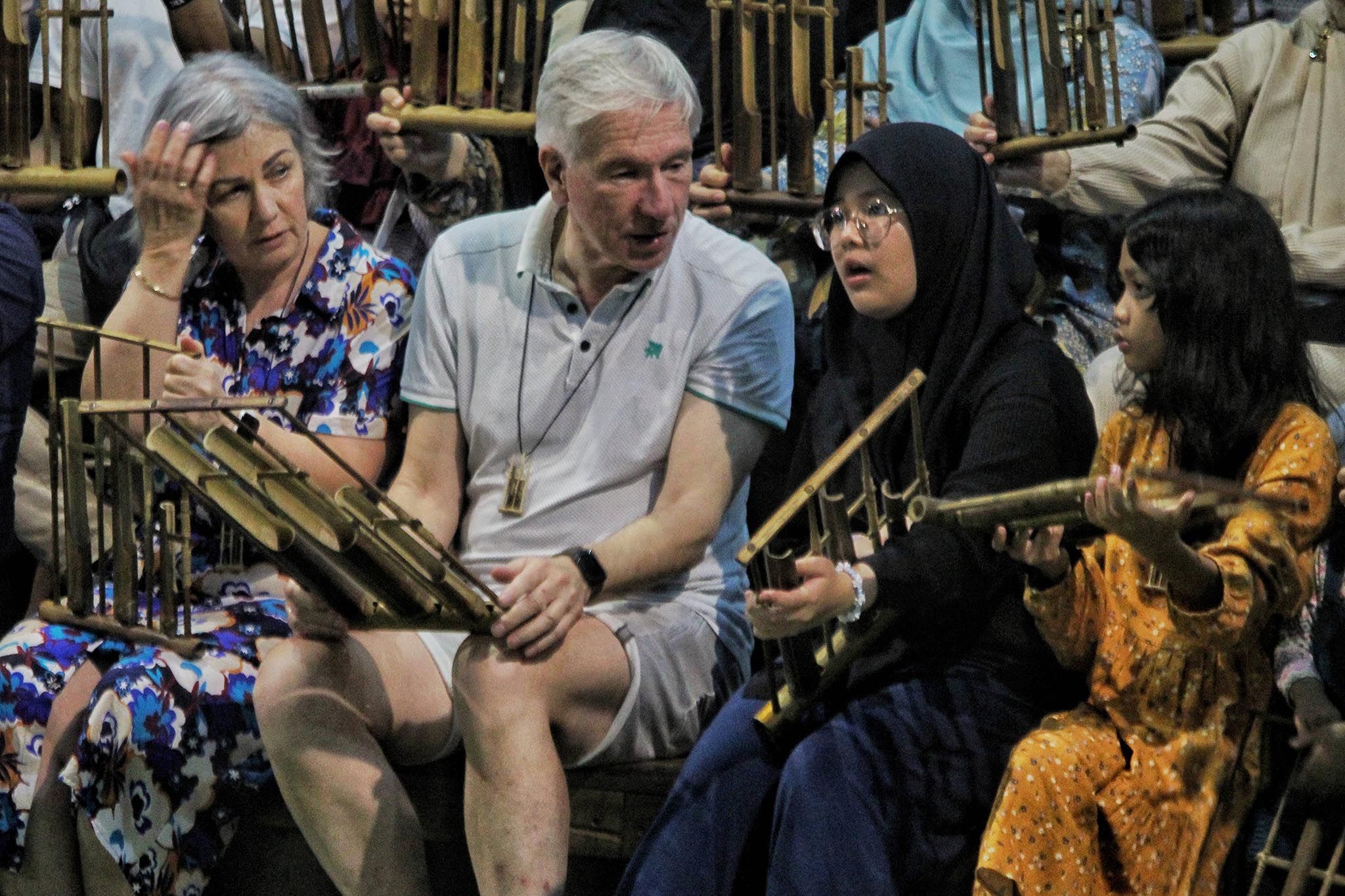 Sejumlah wisatawan memainkan alat musik tradisional di Saung Angklung Udjo, Jalan Padasuka, Kota Bandung, Jumat (12/4/2024).*