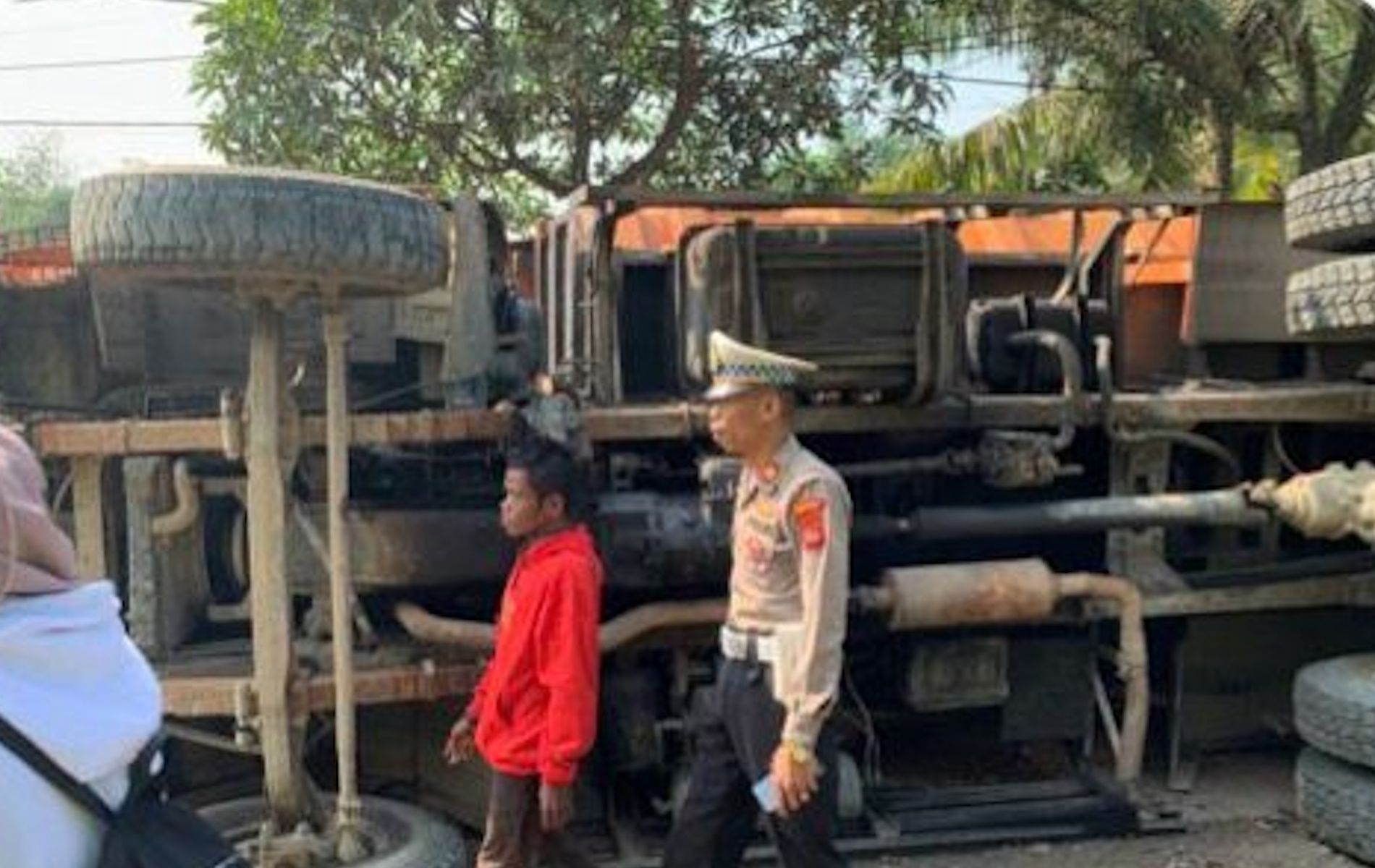 Petugas Polres Bogor tengah melakukan evakuasi terhadap satu unit truk muatan tanah yang terguling.