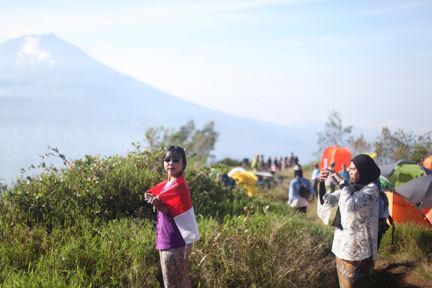 Perempuan berkebaya peserta Women Adventure Camp 2024 saat berpose dengan bendera Indonesia di puncak Gunung Kembang via Blembem, Wonosobo, Jawa Tengah, tepat pada peringatan Hari Kartini, Ahad, 21 April 2024.
