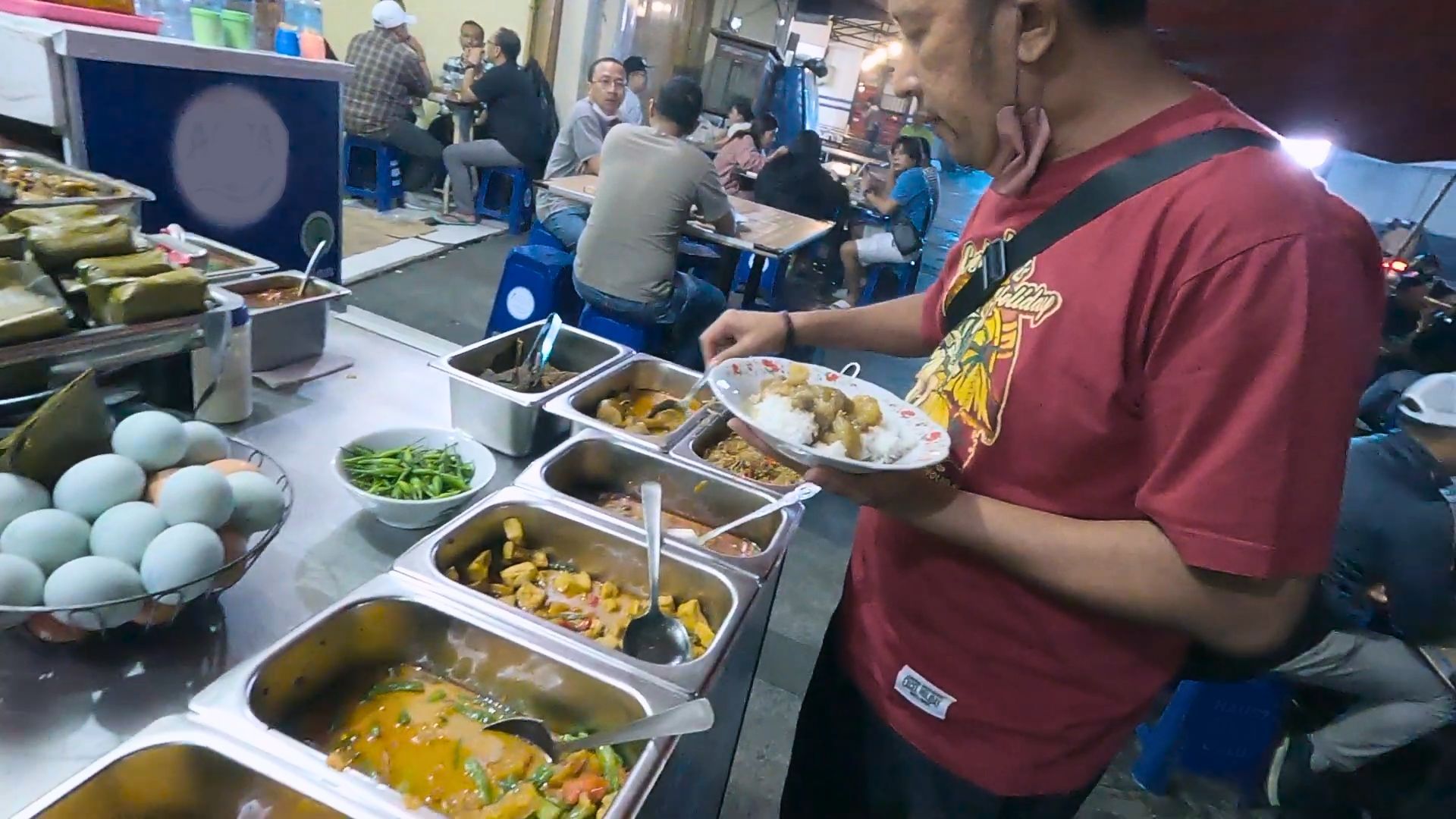 Seorang pengunjung sedang memilih menu di Warung Nasi Ceu Mar Braga./ YouTube/ Sang Pensiunan