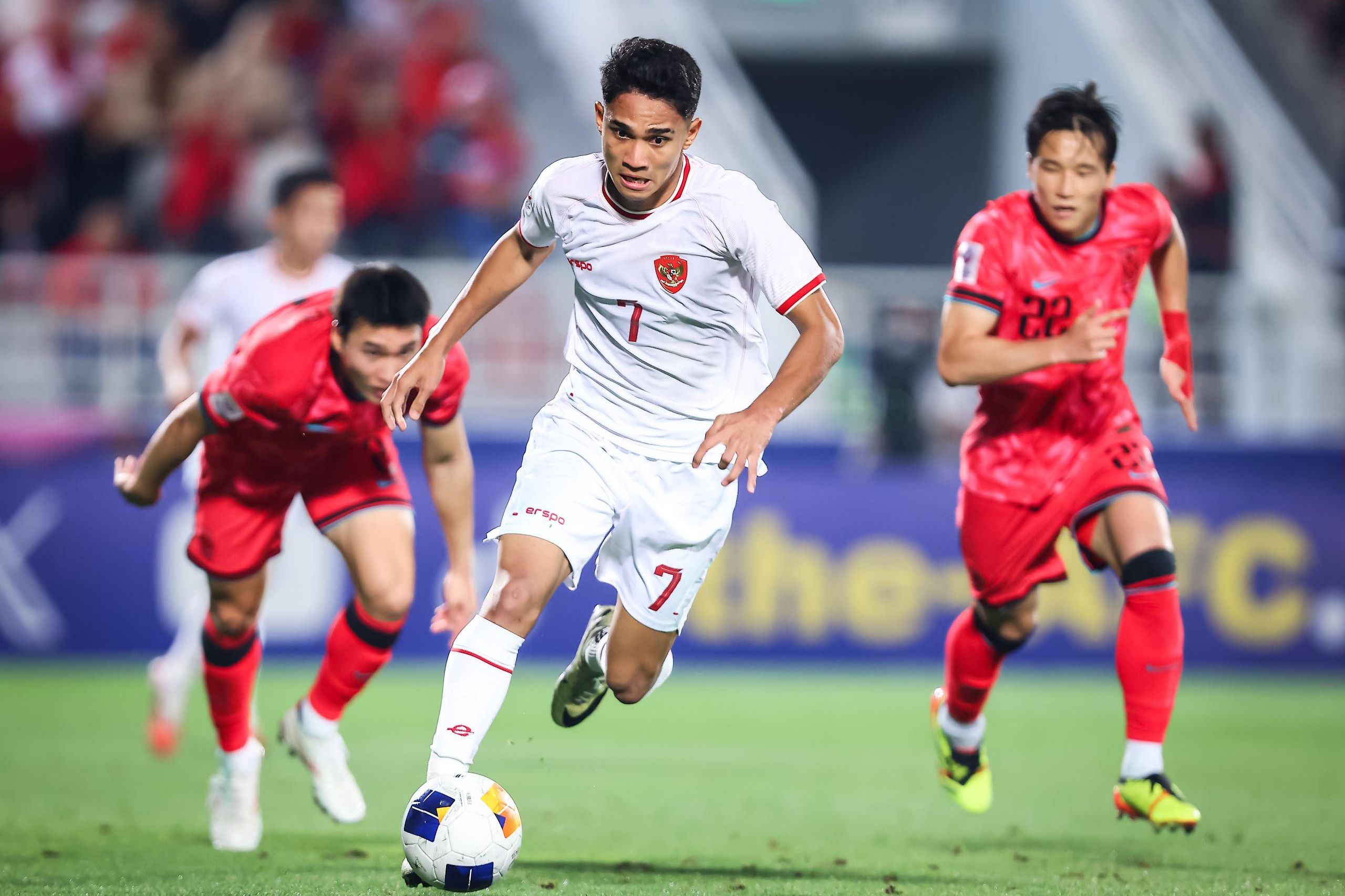 Pesepak bola Timnas U-23 Indonesia Marselino Ferdinan (tengah) melewati dua pesepak bola Timnas U-23 Korea Selatan pada babak perempat final Piala Asia U-23 2024 di Stadion Abdullah bin Khalifa, Doha, Qatar, Jumat (26/4/2024) dini hari. Timnas U-23 Indonesia lolos ke semifinal Piala Asia U-23 setelah mengalahkan Korea Selatan melalui adu pinalti dengan agregat 11-10, setelah sebelumnya bermain imbang dengan skor 2-2.