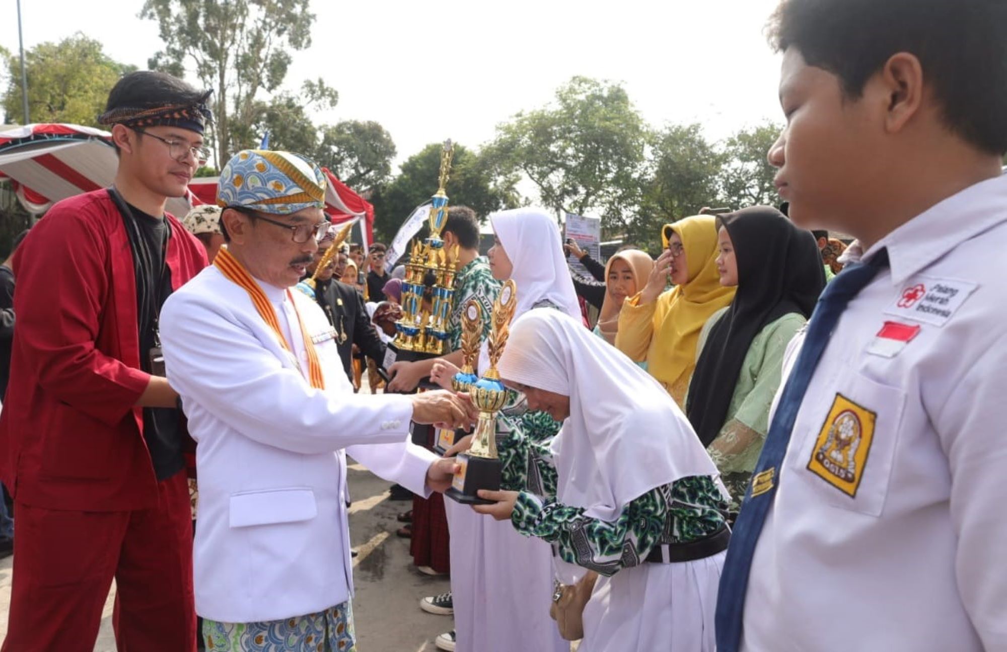 Pj Bupati Kuningan, H. Raden Iip Hidajat menyerahkan piala dan penghargaan kepada siswa SMPN 1 Kuningan.