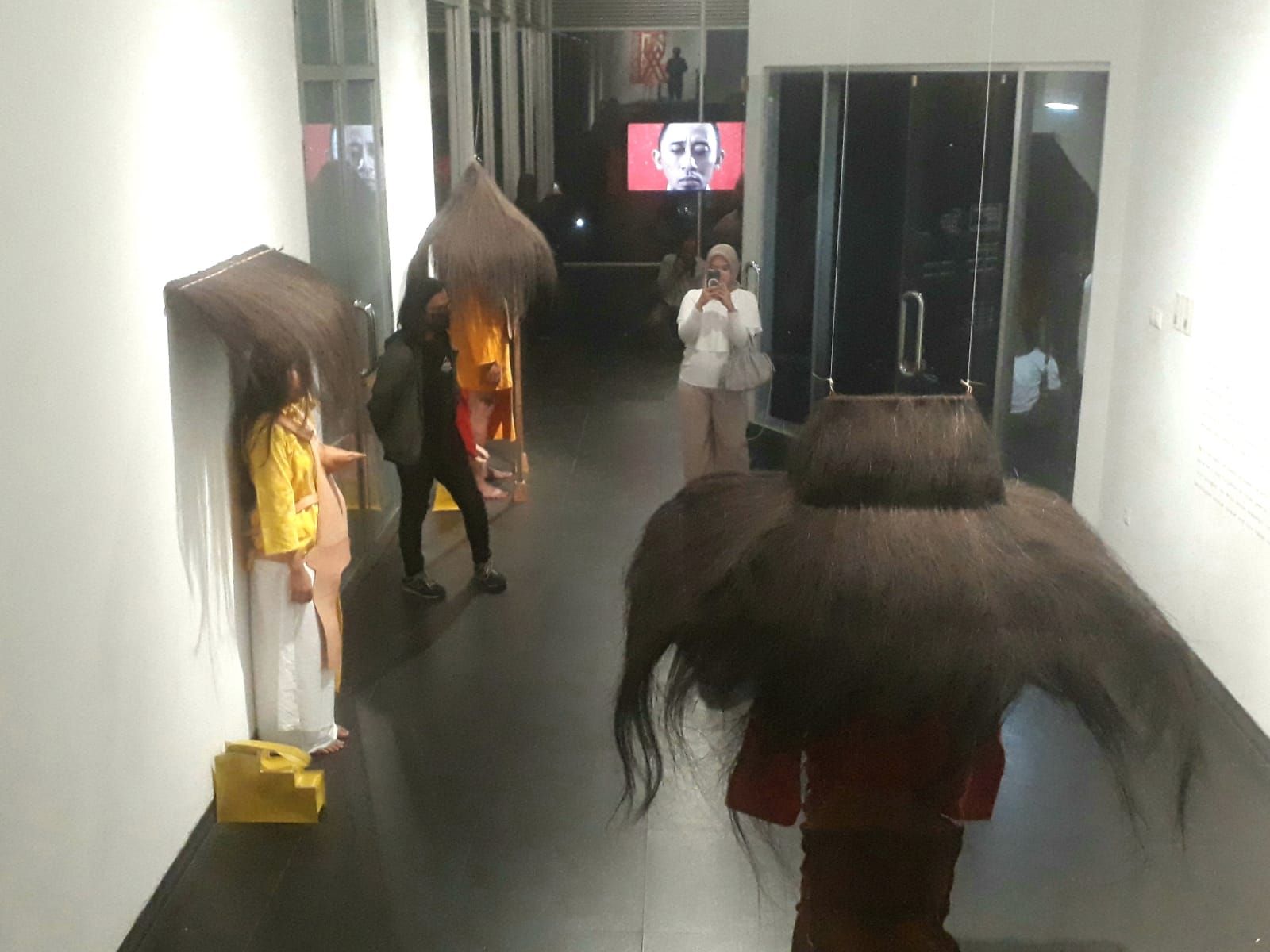 Pengunjung pameran berfoto pada salah satu instalasi seni kostum karya Mella Jaarsma pada pameran tunggal "Tiga Pasang Tangan" di Lawangwangi Creative Space, Bandung Barat, yang berlangsung pada tanggal 10 Mei sampai 10 Juni 2024