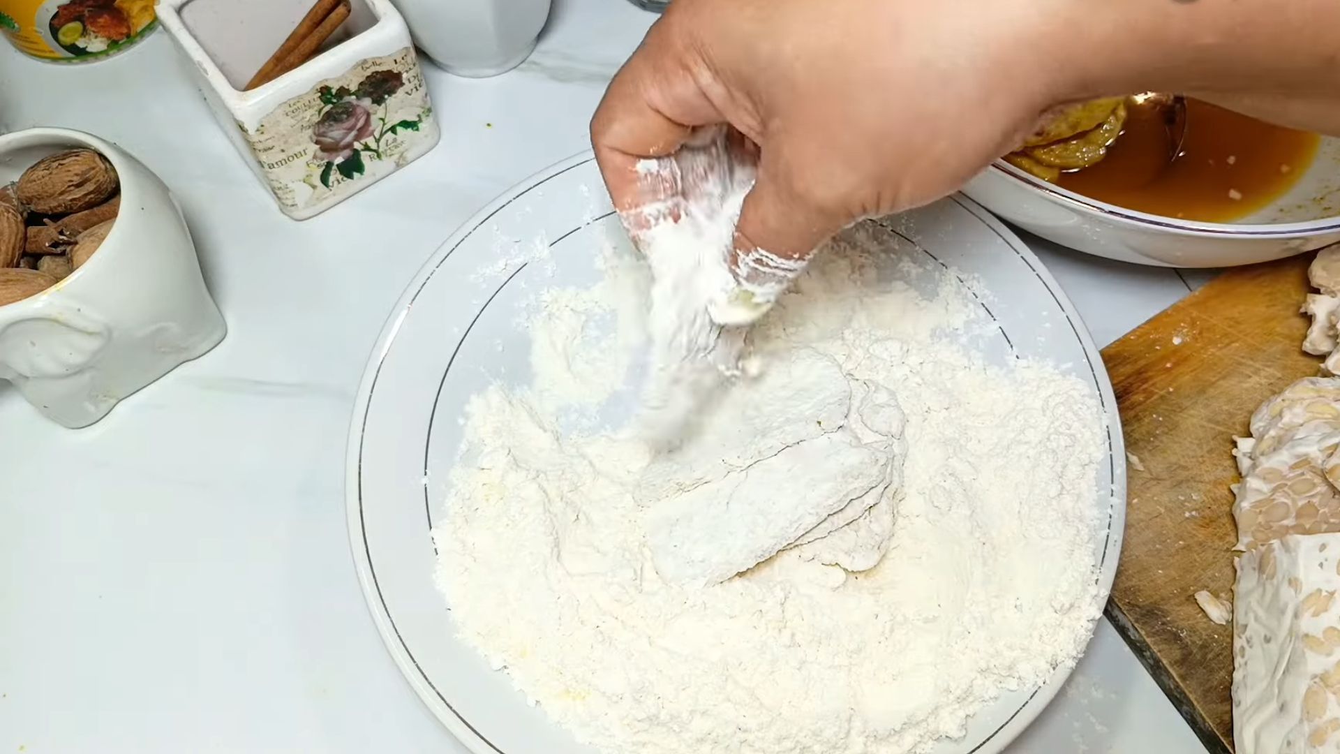 Salah satu proses membuat tempe goreng tepung adalah melumuri dengan tepung. bisa pilih tepung beras atau tepung terigu./ YouTube/ MbokMidut