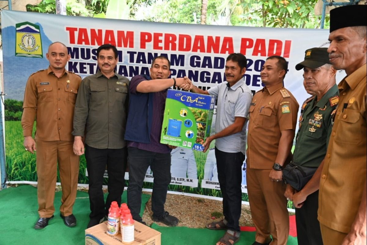 Pj Bupati Aceh Besar, Muhammad Iswanto, S.STP MM menyerahkan alat penyemprotan kepada petani dalam kegiatan menanam padi perdana Tahun 2024 di area persawahan Gampong Lamkawe, Kecamatan Darul Imarah, Aceh Besar, Selasa (04/06/2024)
