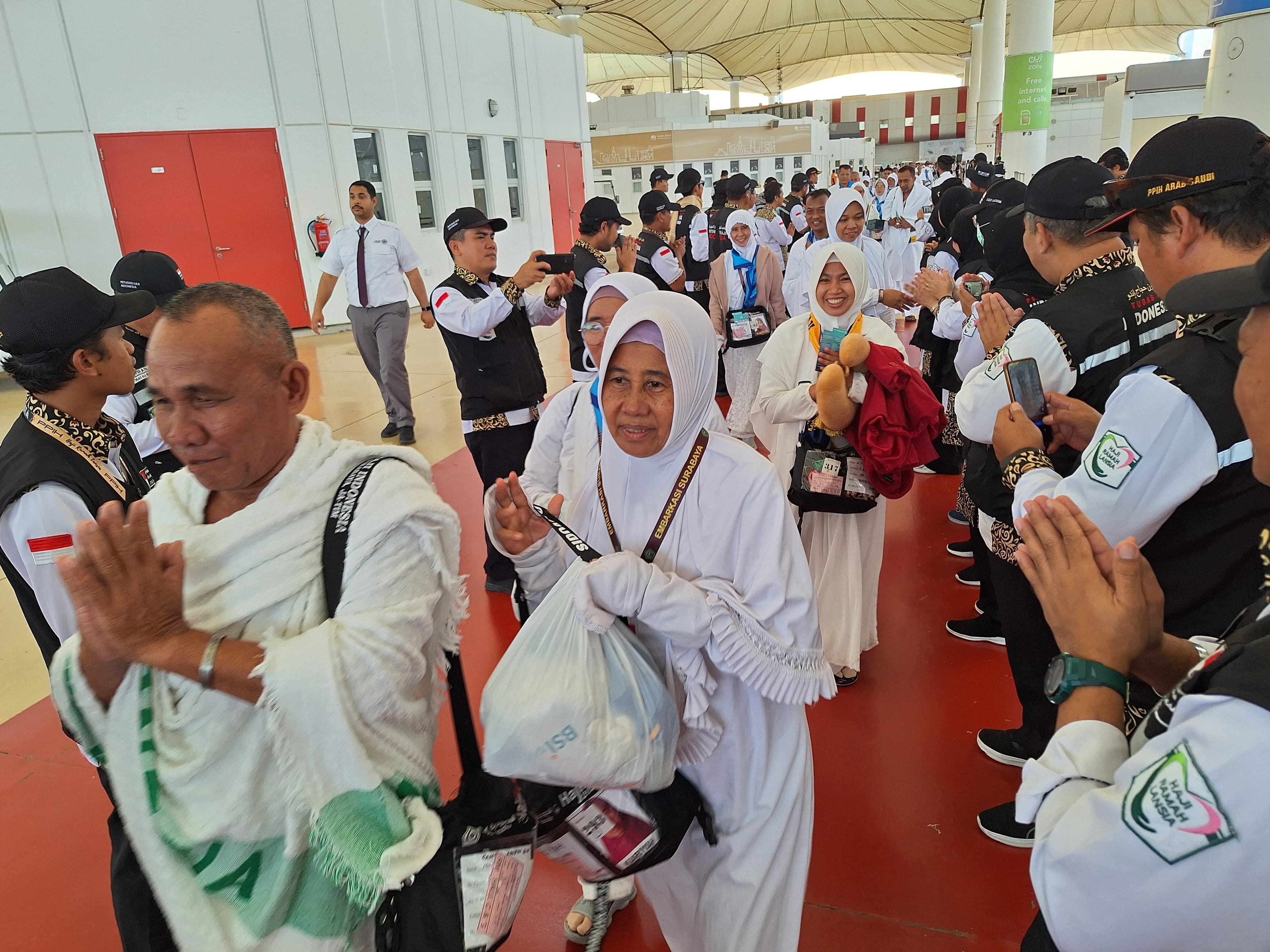 Petugas Penyelenggara Ibadah Haji (PPIH) Arab Saudi menyambut kedatangan jemaah haji kelompok terbang (kloter) SUB-106 dari Embarkasi Surabaya di Bandara Internasional King Abdul Aziz, Jeddah, Selasa, 11 Juni 2024.* - 