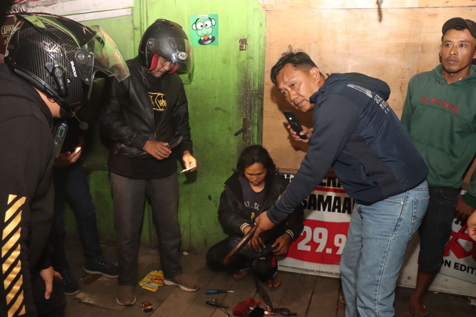 Personil kepolisian Resort Kota Sukabumi tengah  menggeledah tas seorang pemuda yang tertangkap basa bawa senjata tajam
