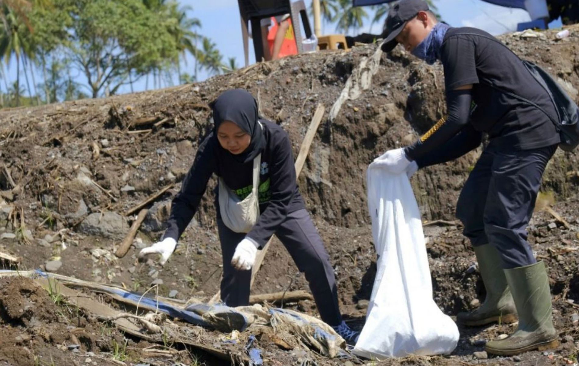 Dua pegawai PT PLN Indonesia Power UBP Ombilin Sawahlunto terlihat memungut benda-benda plastik lalu di masukan ke karung untuk dibawa ke pembuangan akhir.