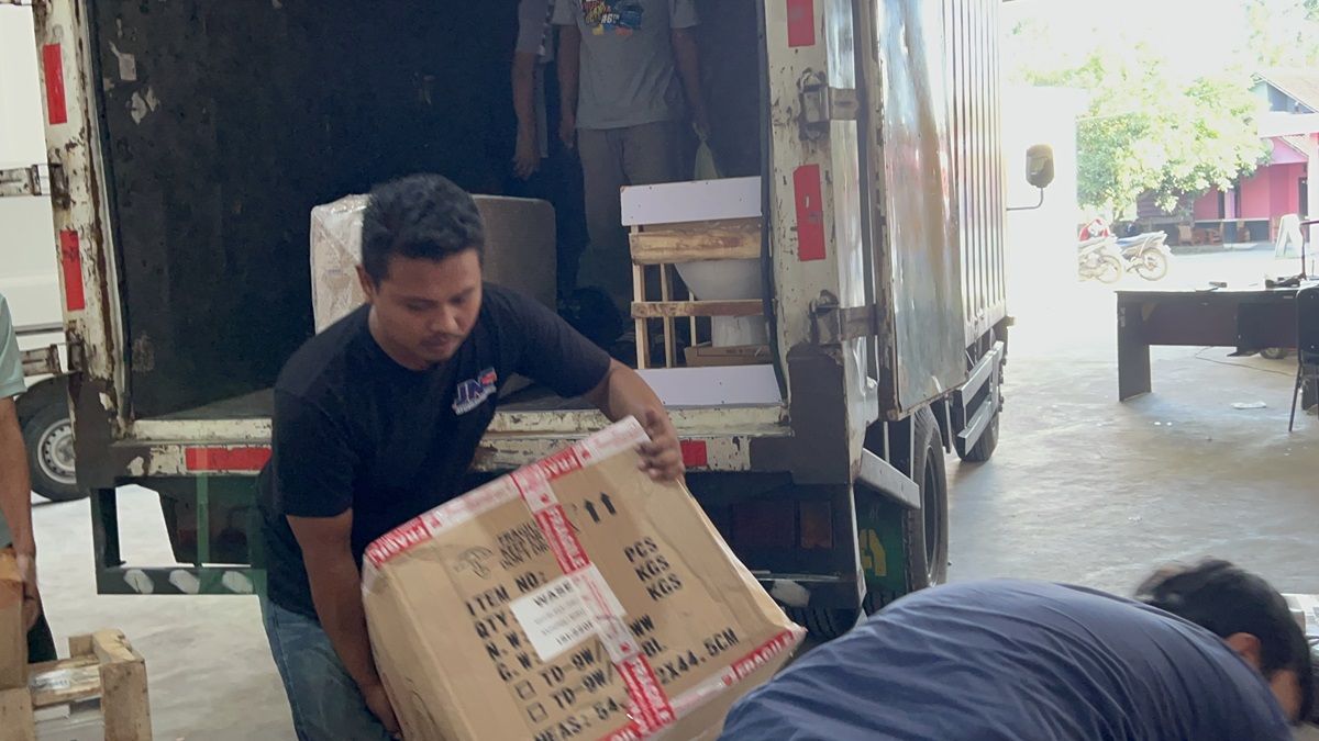 Danu Kurniawan tampak ikut menurunkan paket barang dari JNE Cabang Yogyakarta.